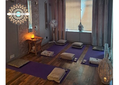 Tranquil meditation room at Sacred Moon Wellbeing in Horbury, England with cushions and soft lighting.