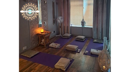 Tranquil meditation room at Sacred Moon Wellbeing in Horbury, England with cushions and soft lighting.