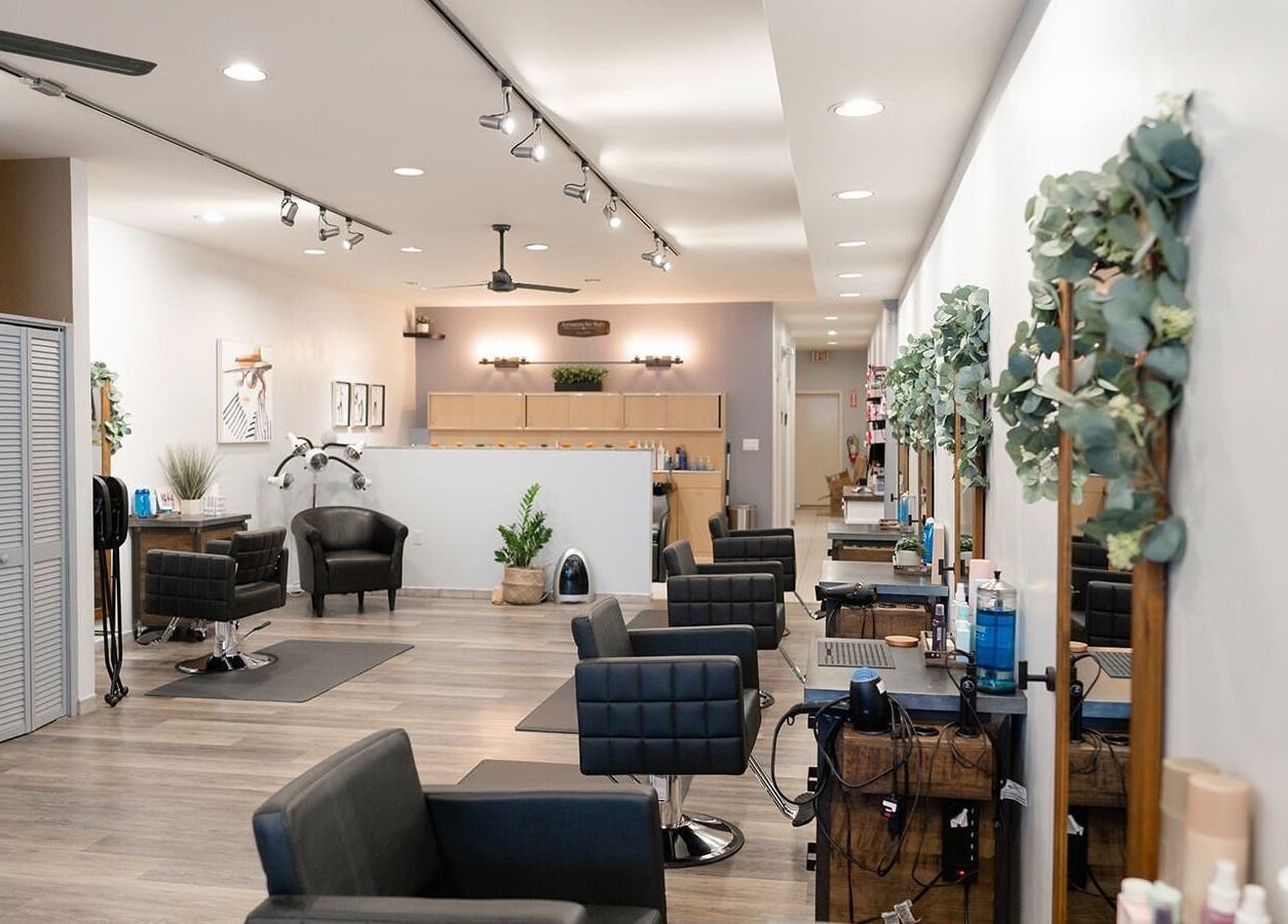 Interior view of Expressions Hair Studio in Reading, Massachusetts, US, featuring stylish black salon chairs.
