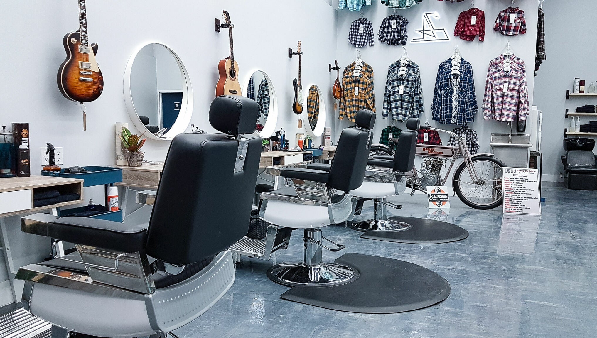 Modern barber chairs at Blackstone Barbers and Beardsmiths in Saskatoon, Saskatchewan, CA, feature guitars and plaid shirts.