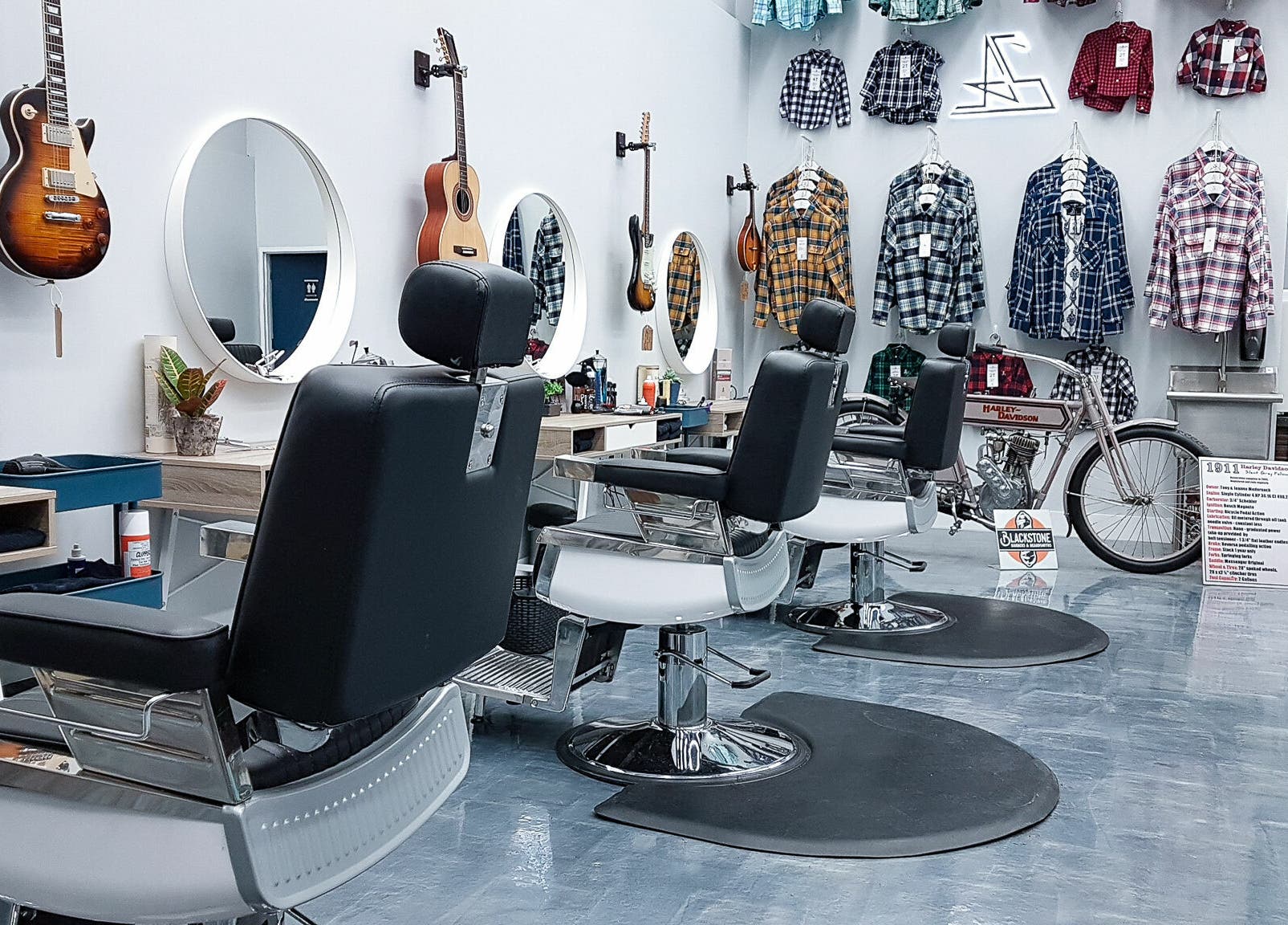 Modern barber chairs at Blackstone Barbers and Beardsmiths in Saskatoon, Saskatchewan, CA, feature guitars and plaid shirts.