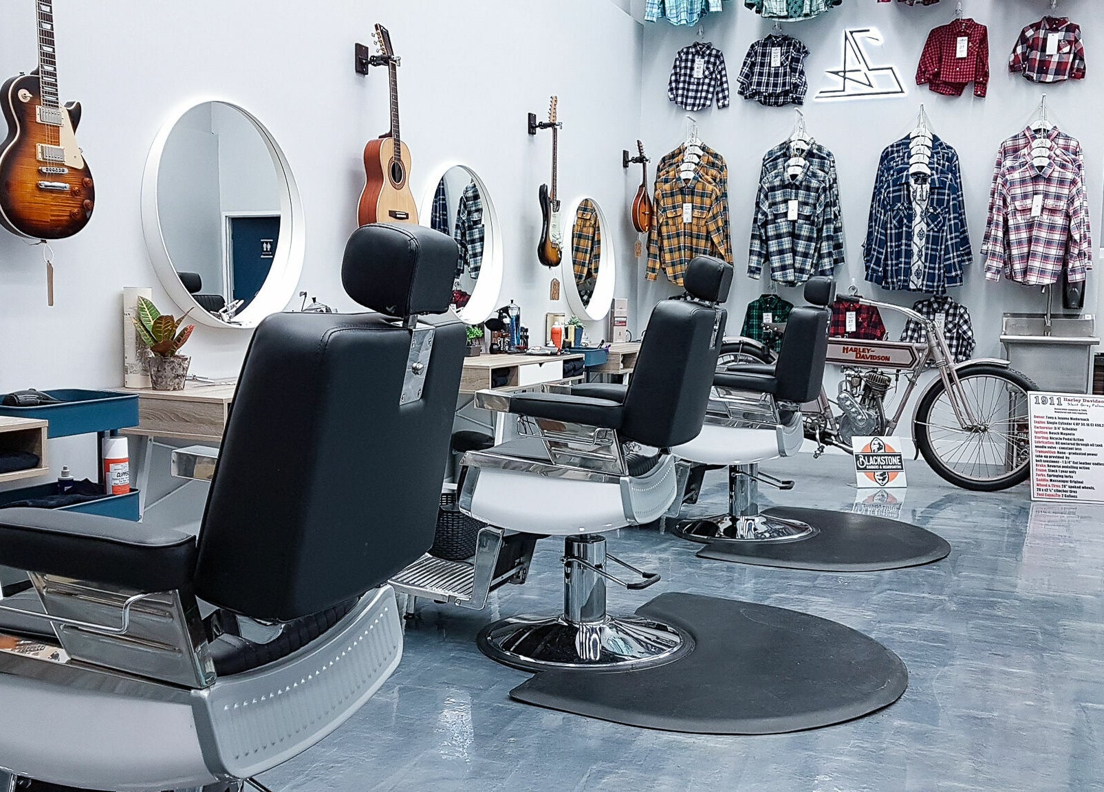 Modern barber chairs at Blackstone Barbers and Beardsmiths in Saskatoon, Saskatchewan, CA, feature guitars and plaid shirts.