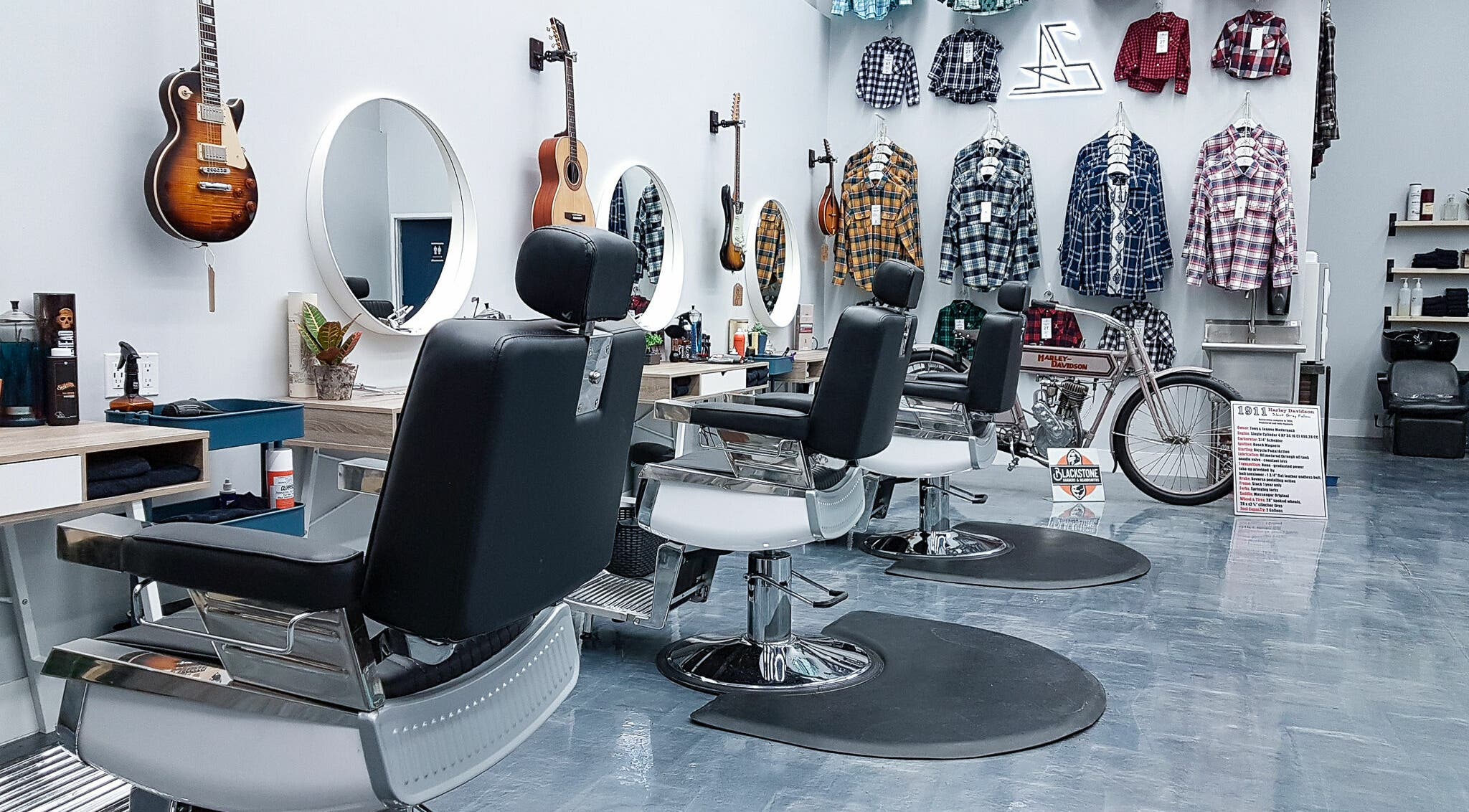 Modern barber chairs at Blackstone Barbers and Beardsmiths in Saskatoon, Saskatchewan, CA, feature guitars and plaid shirts.