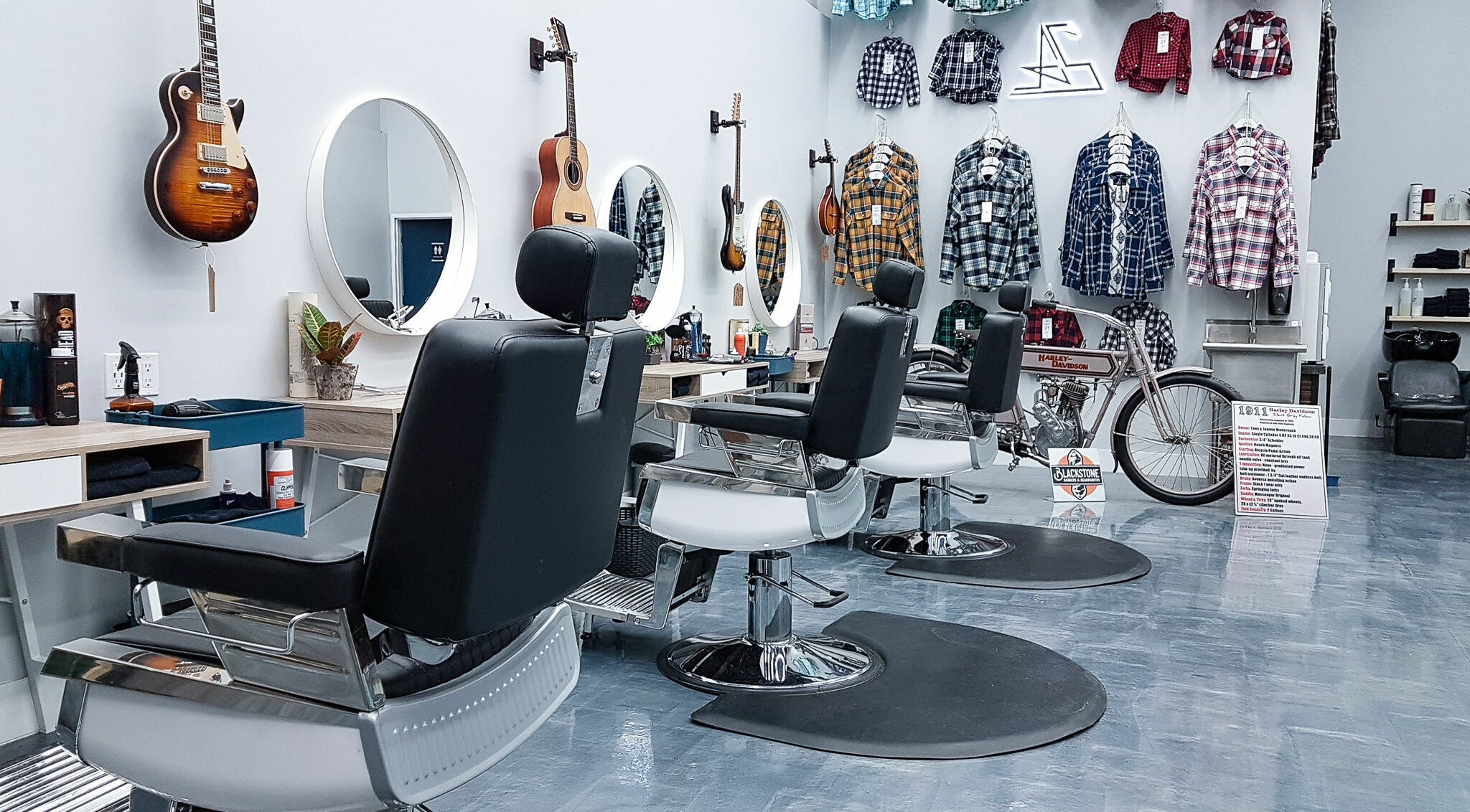 Modern barber chairs at Blackstone Barbers and Beardsmiths in Saskatoon, Saskatchewan, CA, feature guitars and plaid shirts.