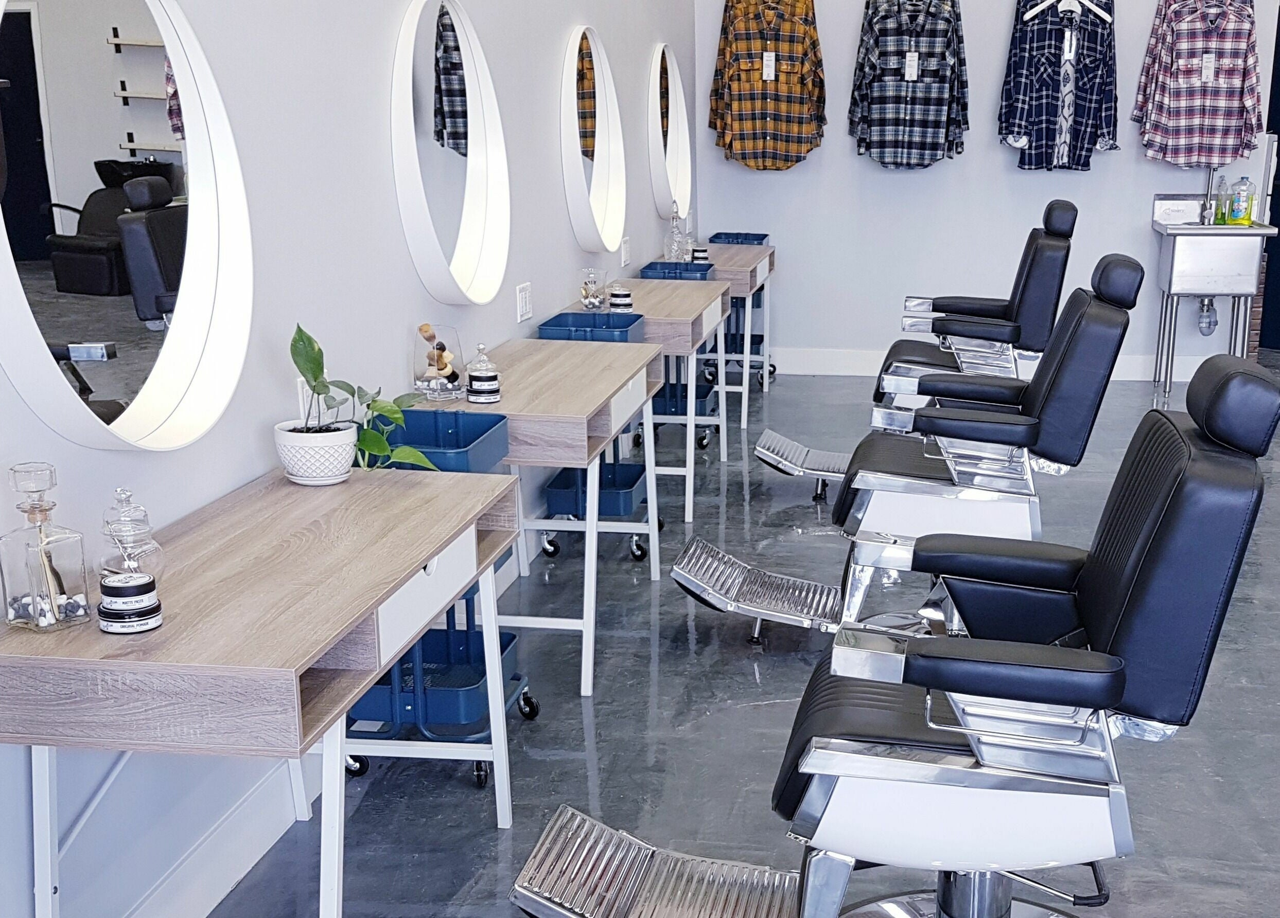 Modern interior of Blackstone Barbers and Beardsmiths in Saskatoon, Saskatchewan, CA, featuring sleek styling stations.