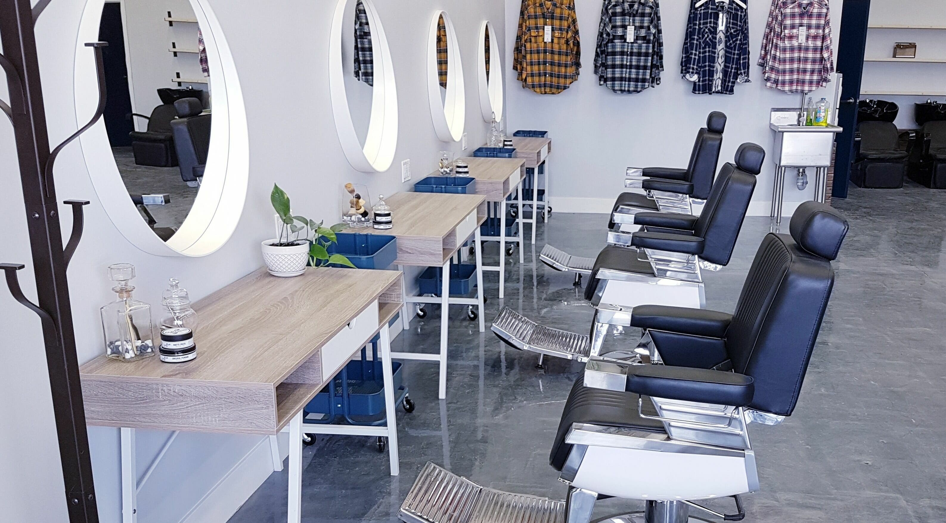 Modern interior of Blackstone Barbers and Beardsmiths in Saskatoon, Saskatchewan, CA, featuring sleek styling stations.
