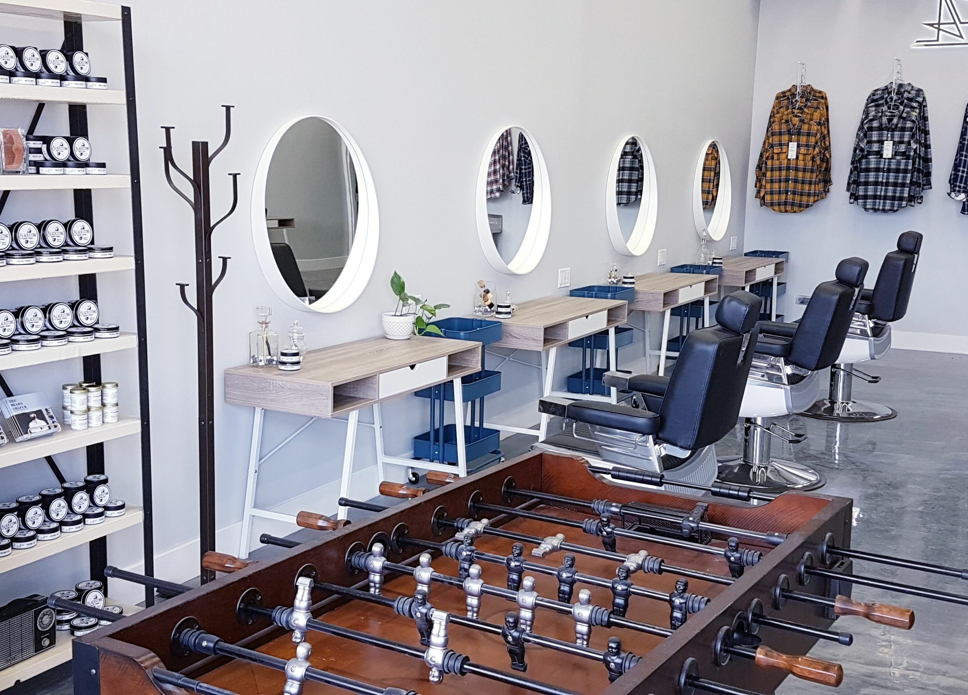 Modern interior of Blackstone Barbers and Beardsmiths, Saskatoon, Saskatchewan, CA with stylish chairs and mirrors.