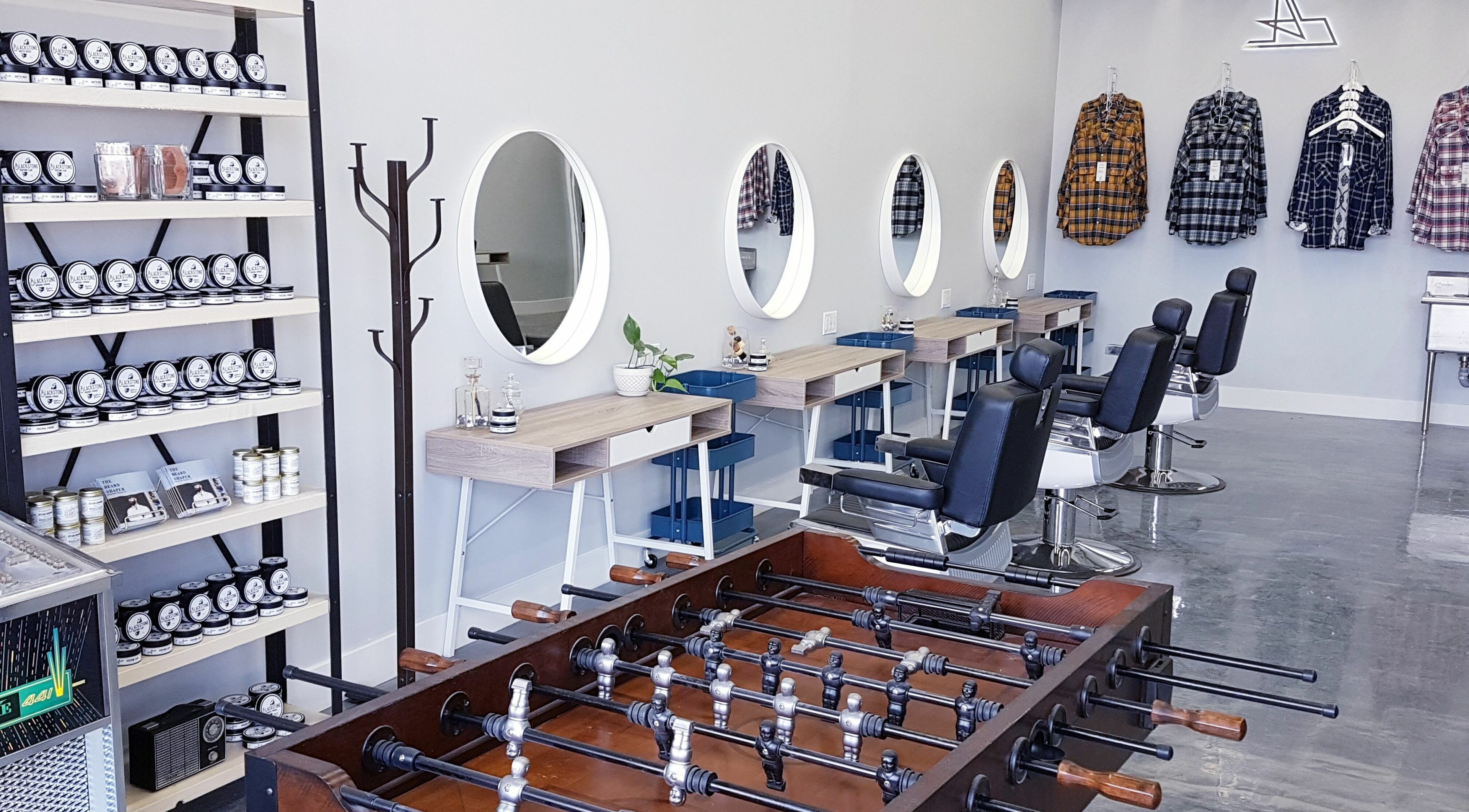 Modern interior of Blackstone Barbers and Beardsmiths, Saskatoon, Saskatchewan, CA with stylish chairs and mirrors.