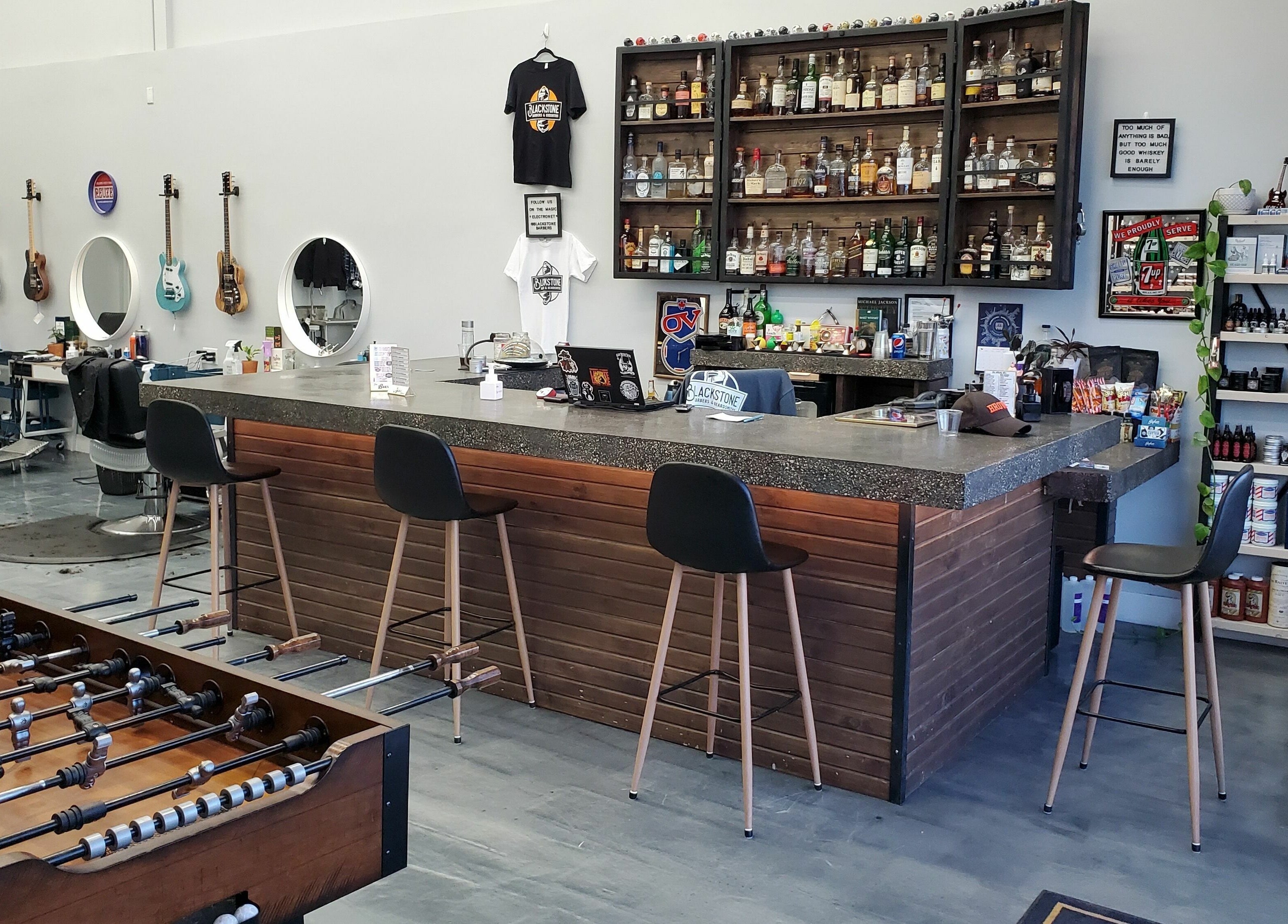 Interior of Blackstone Barbers and Beardsmiths in Saskatoon, Saskatchewan, CA with a modern barber setup and bar.
