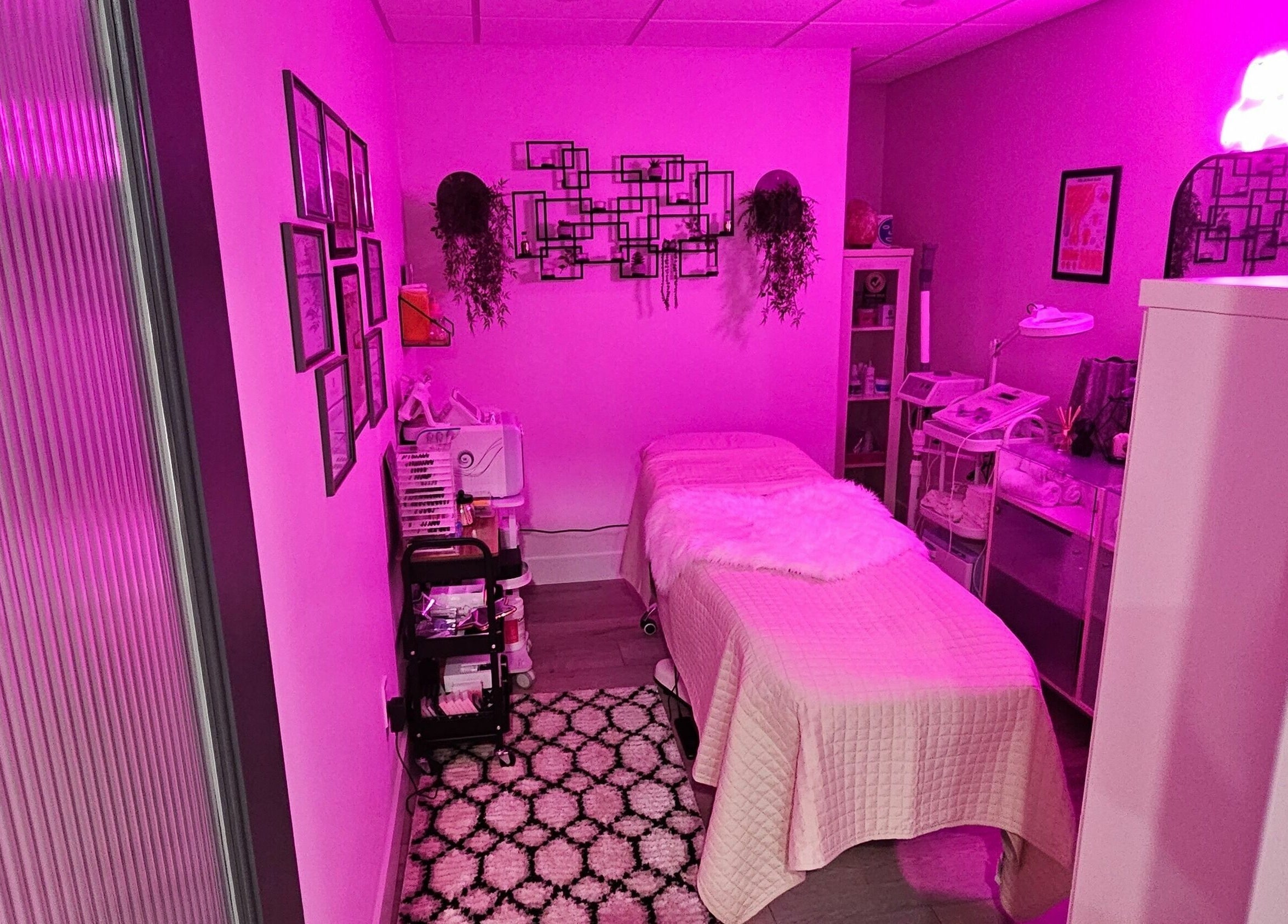 Cozy beauty treatment room at Simply BeYoutiful PMU in St. Albert, Alberta, CA with vibrant pink lighting.