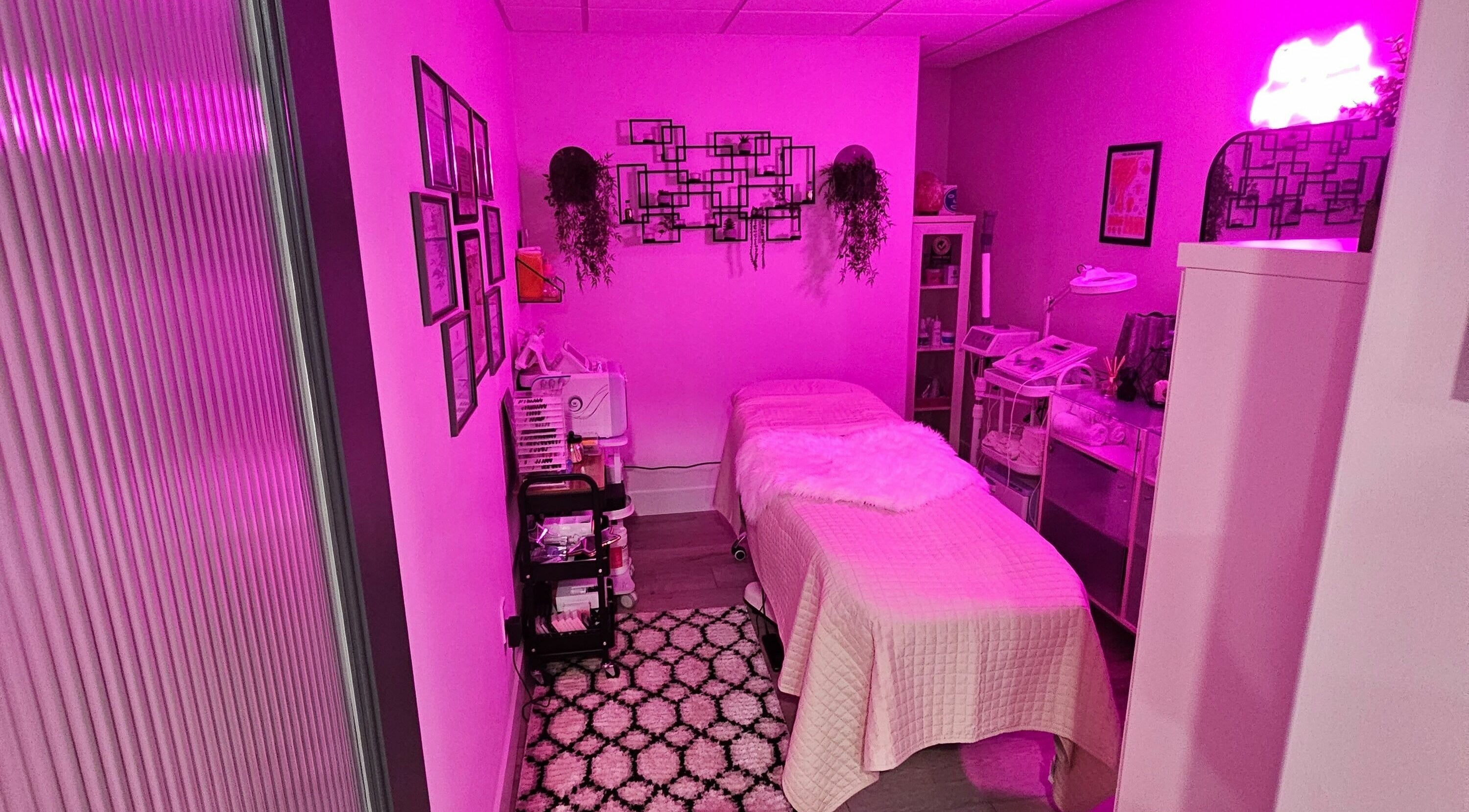 Cozy beauty treatment room at Simply BeYoutiful PMU in St. Albert, Alberta, CA with vibrant pink lighting.