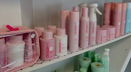DesignMe hair products on shelf at Hair Tracks, Oshawa, Ontario, CA. Vibrant pink packaging highlights range.
