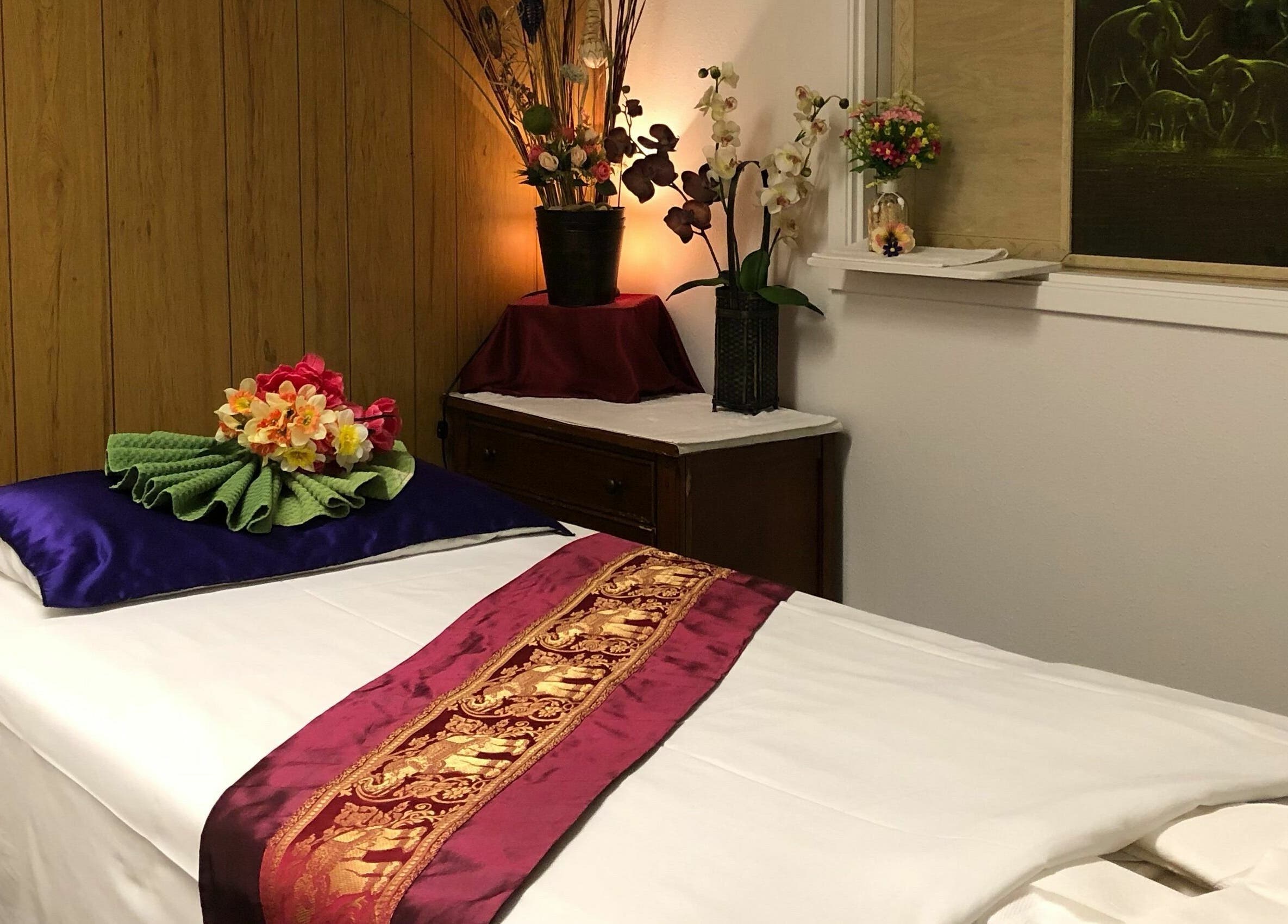 Relaxing massage room with floral decor at Jamjuree Massage, Clovis, California, US, offering a tranquil escape.