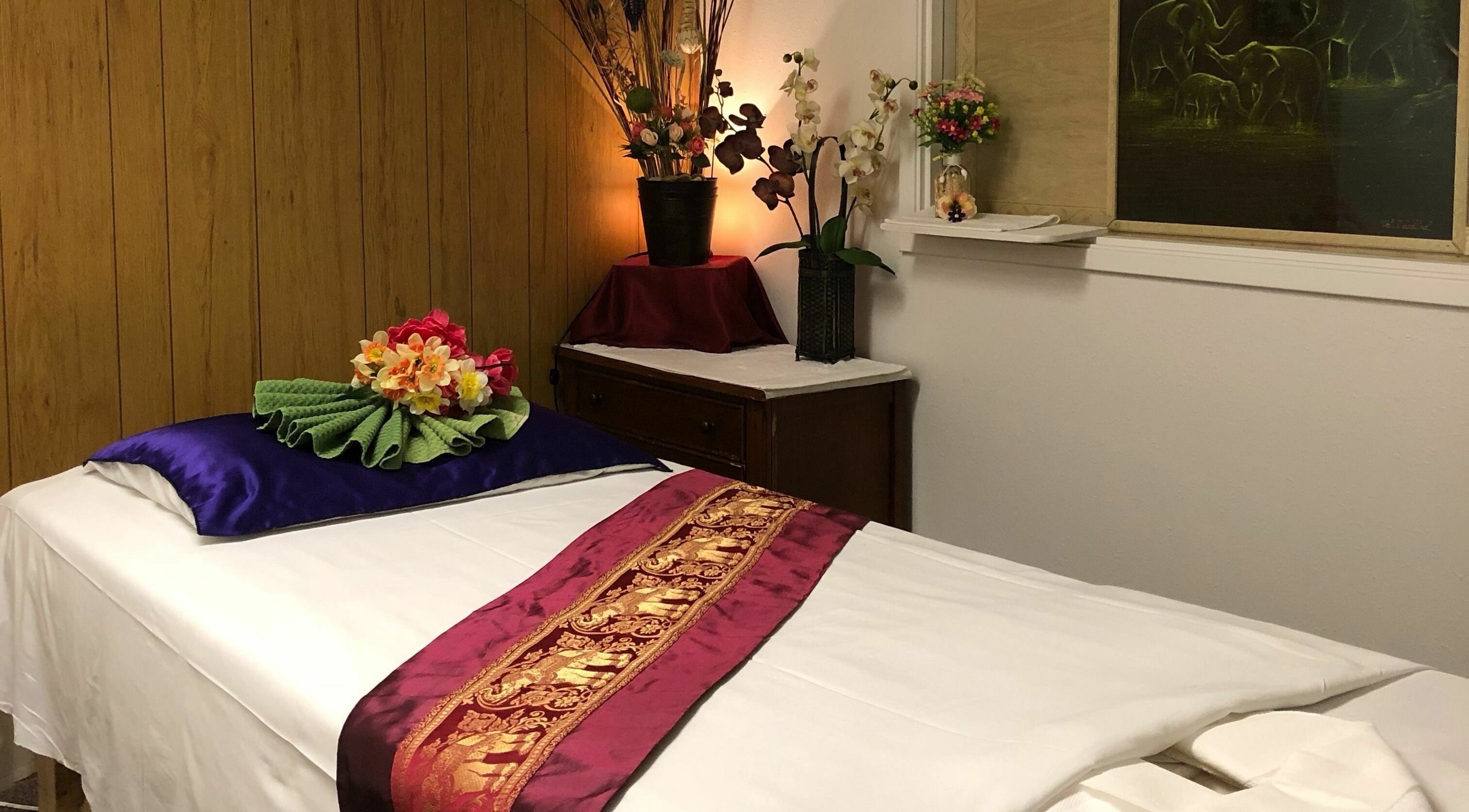 Relaxing massage room with floral decor at Jamjuree Massage, Clovis, California, US, offering a tranquil escape.