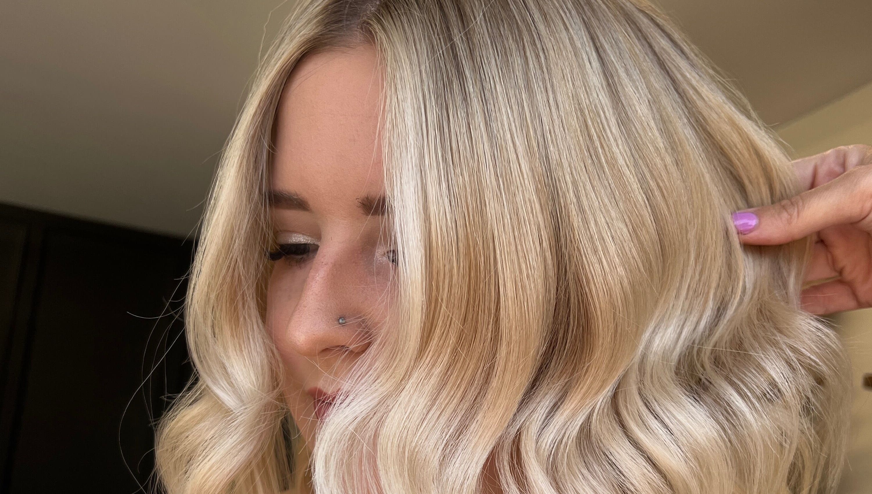 Stylish blonde hairstyle at Mirror on the Wall in Stalham, England, GB, featuring soft waves and sleek finish.