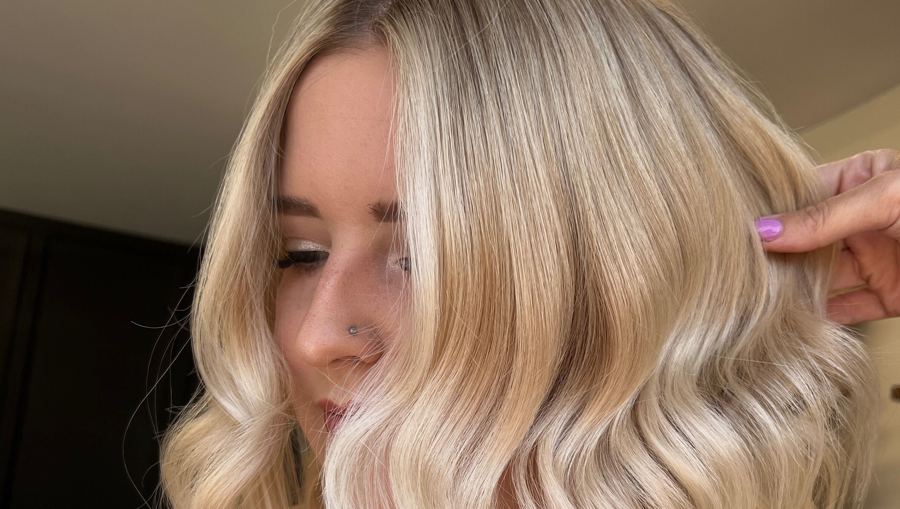 Stylish blonde hairstyle at Mirror on the Wall in Stalham, England, GB, featuring soft waves and sleek finish.