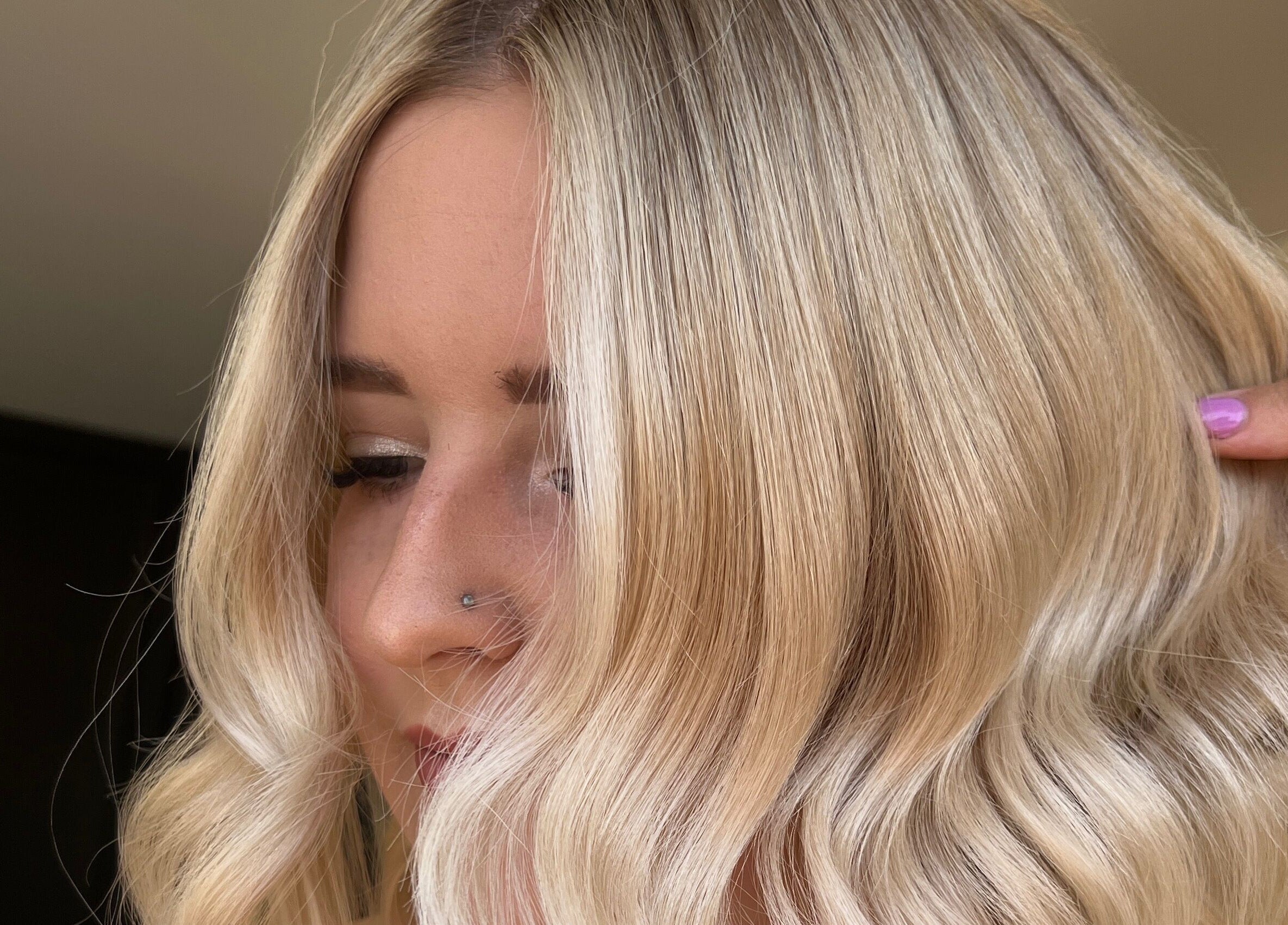 Stylish blonde hairstyle at Mirror on the Wall in Stalham, England, GB, featuring soft waves and sleek finish.