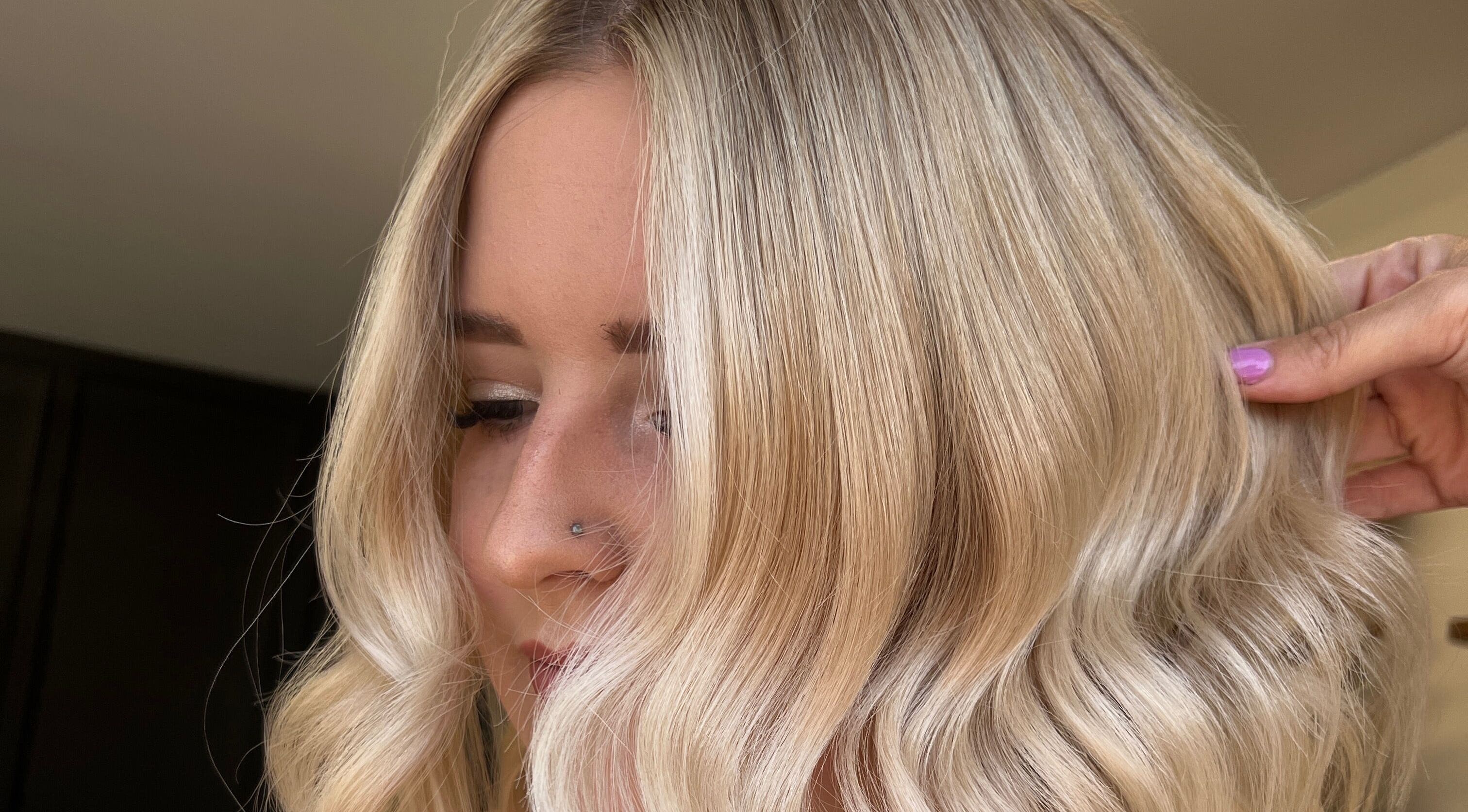 Stylish blonde hairstyle at Mirror on the Wall in Stalham, England, GB, featuring soft waves and sleek finish.