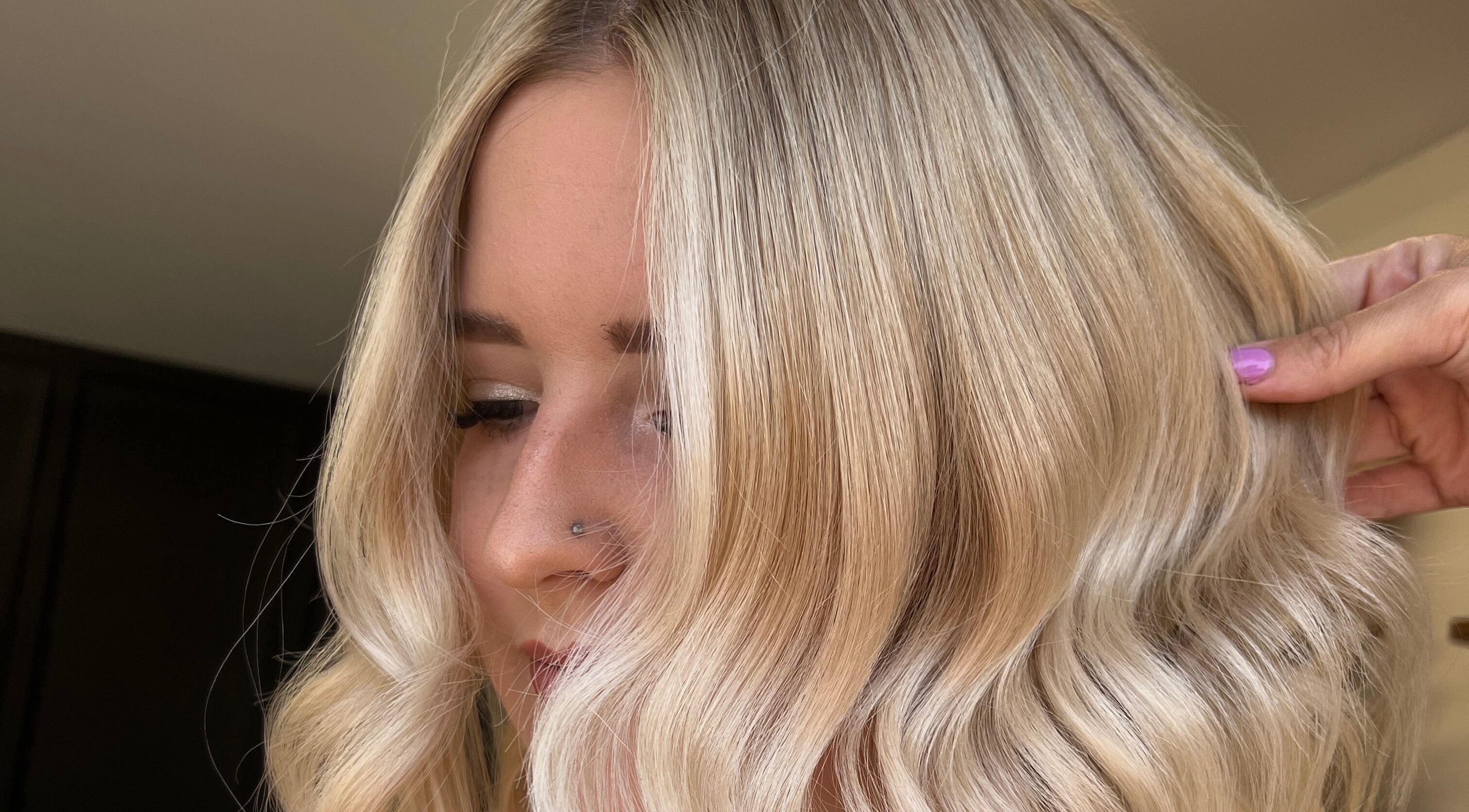 Stylish blonde hairstyle at Mirror on the Wall in Stalham, England, GB, featuring soft waves and sleek finish.