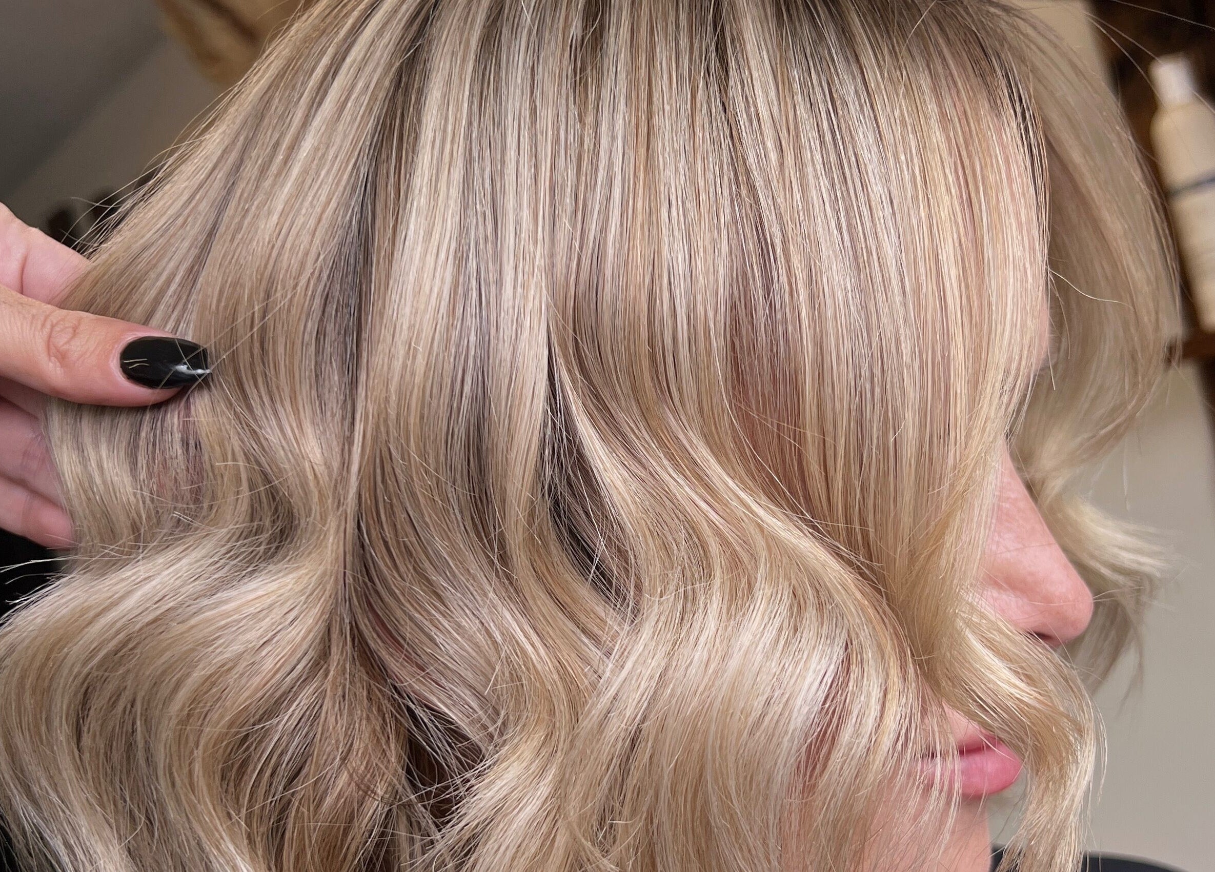 Blonde hair styled into soft waves at Mirror on the Wall salon, Stalham, England, GB.