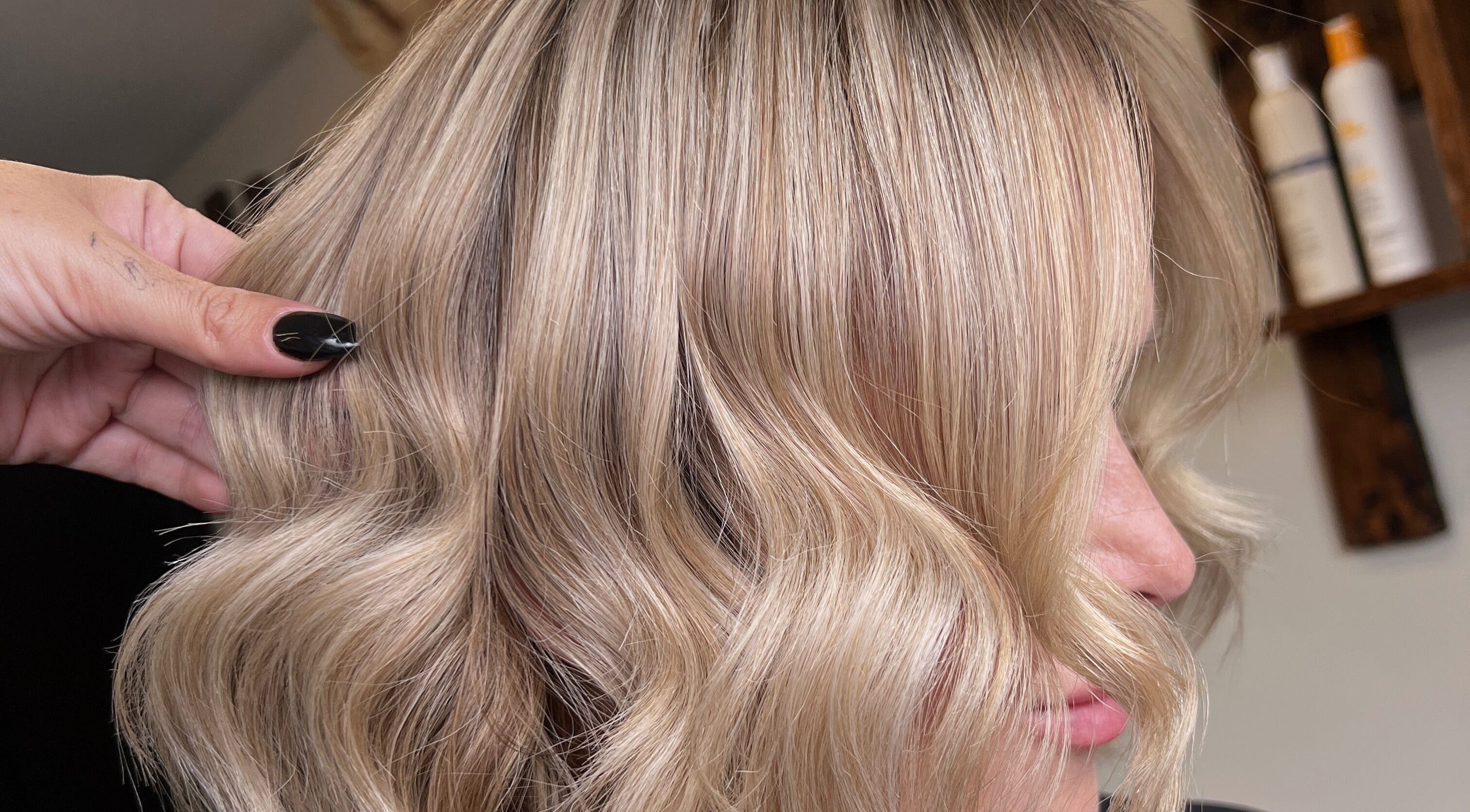 Blonde hair styled into soft waves at Mirror on the Wall salon, Stalham, England, GB.
