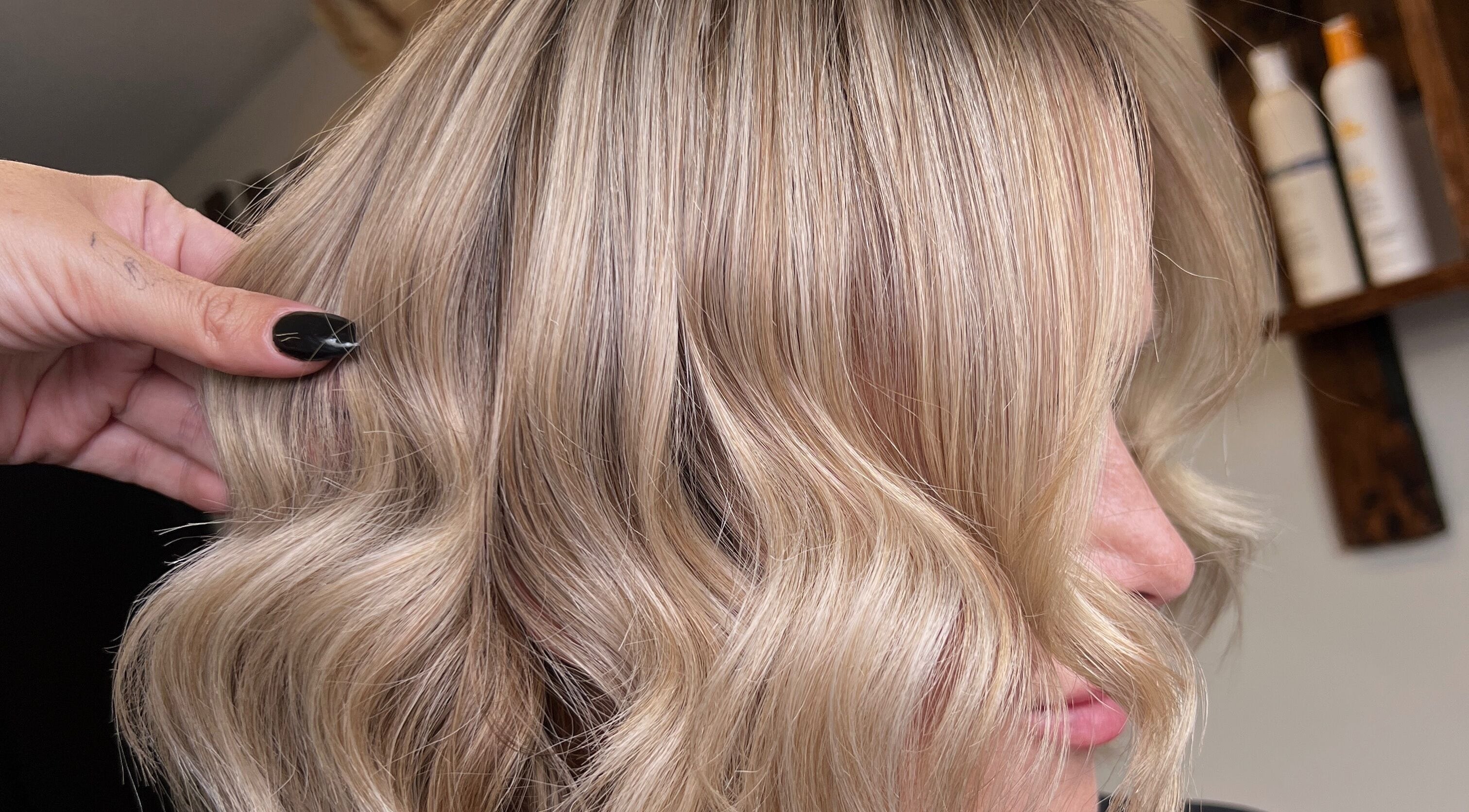 Blonde hair styled into soft waves at Mirror on the Wall salon, Stalham, England, GB.