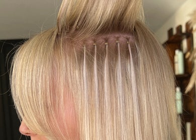 Hair extensions application at Mirror on the Wall in Stalham, England, GB showcasing precision technique.