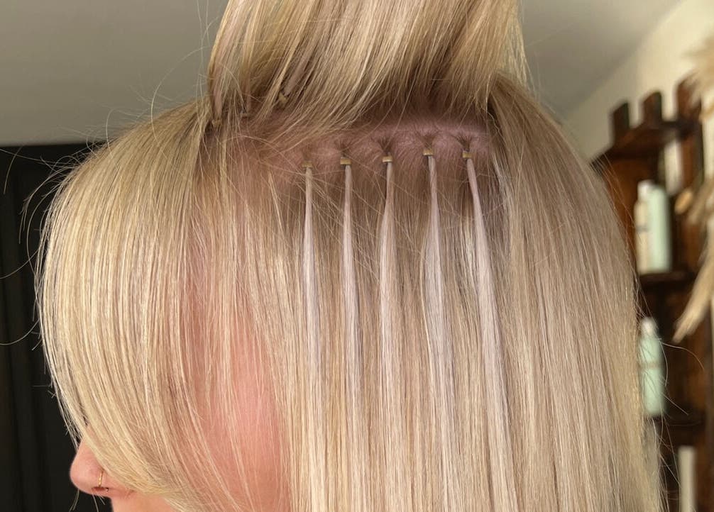 Hair extensions application at Mirror on the Wall in Stalham, England, GB showcasing precision technique.