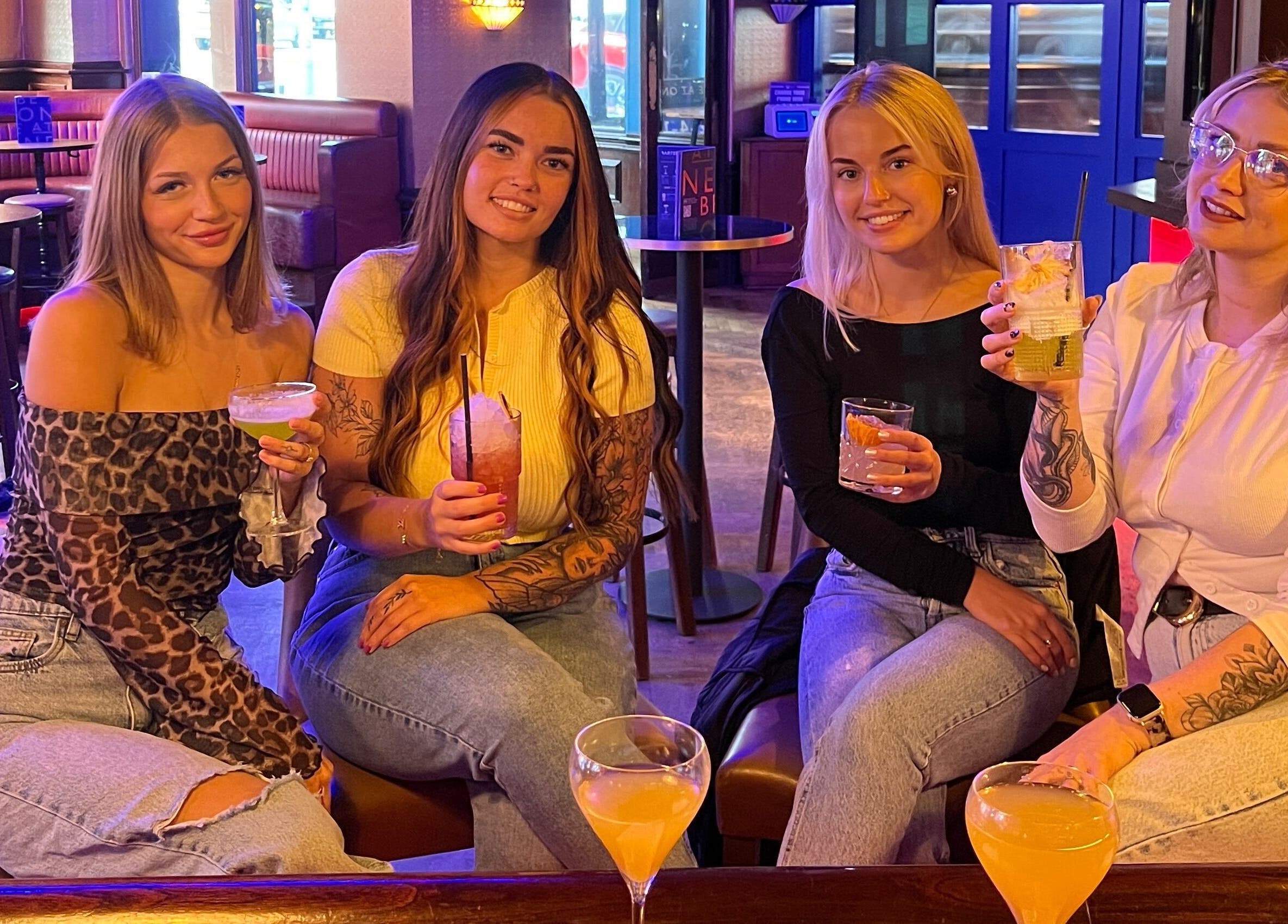 Group enjoying drinks at Mirror on the Wall, Stalham, England, GB. Warm atmosphere, friendly faces.