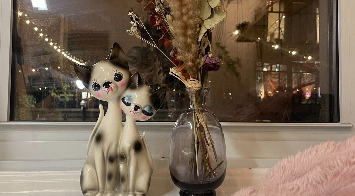 Whimsical ceramic cats by a vase at Lehita Lashes Artistry, Montréal, Québec, CA, creating a cozy ambiance.