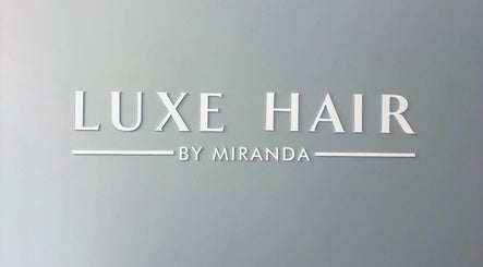 Luxe Hair signage on a gray wall in Tamworth, New South Wales, AU, showcasing salon identity.