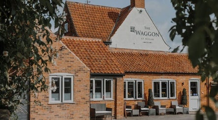 Charming exterior of Halam Salon in Newark, England, GB, featuring rustic brickwork and inviting seating.