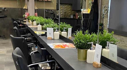Modern interior of Halam Salon in Newark, England, GB with chic seating, mirrors, and fresh plants.