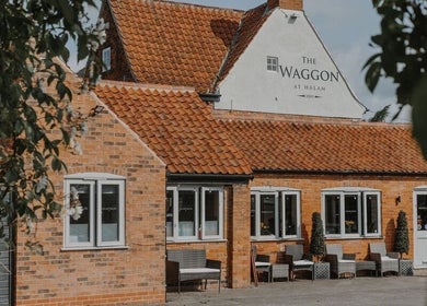 Exterior of Halam Salon in Newark, England, GB, featuring rustic brick facade and cozy seating.
