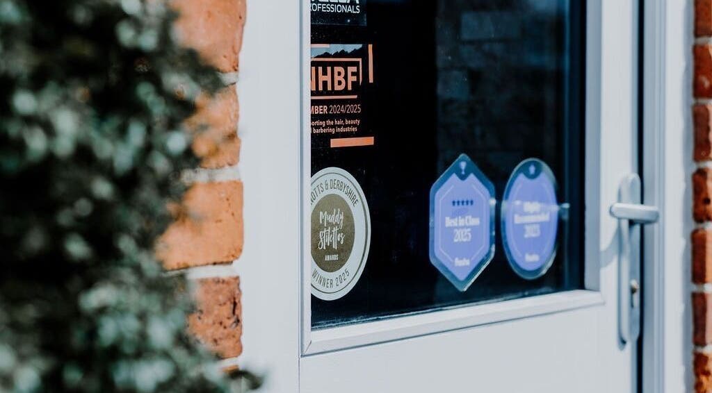 Close-up of award stickers on Halam Salon door at Newark, England, GB, celebrating excellence in beauty and wellness.