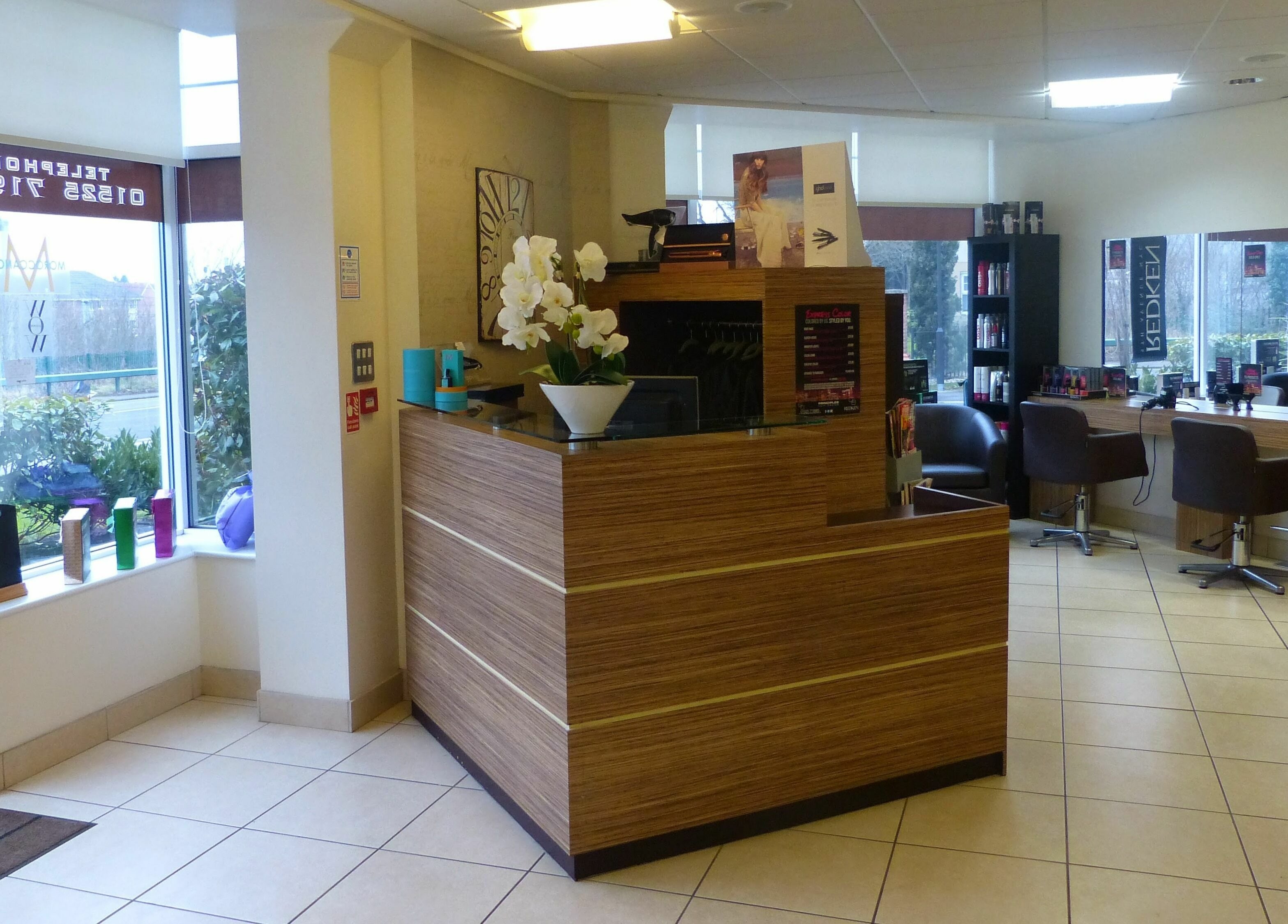 Reception area of Principles Hair Design Ltd in Flitwick, England, GB featuring modern decor and seating.