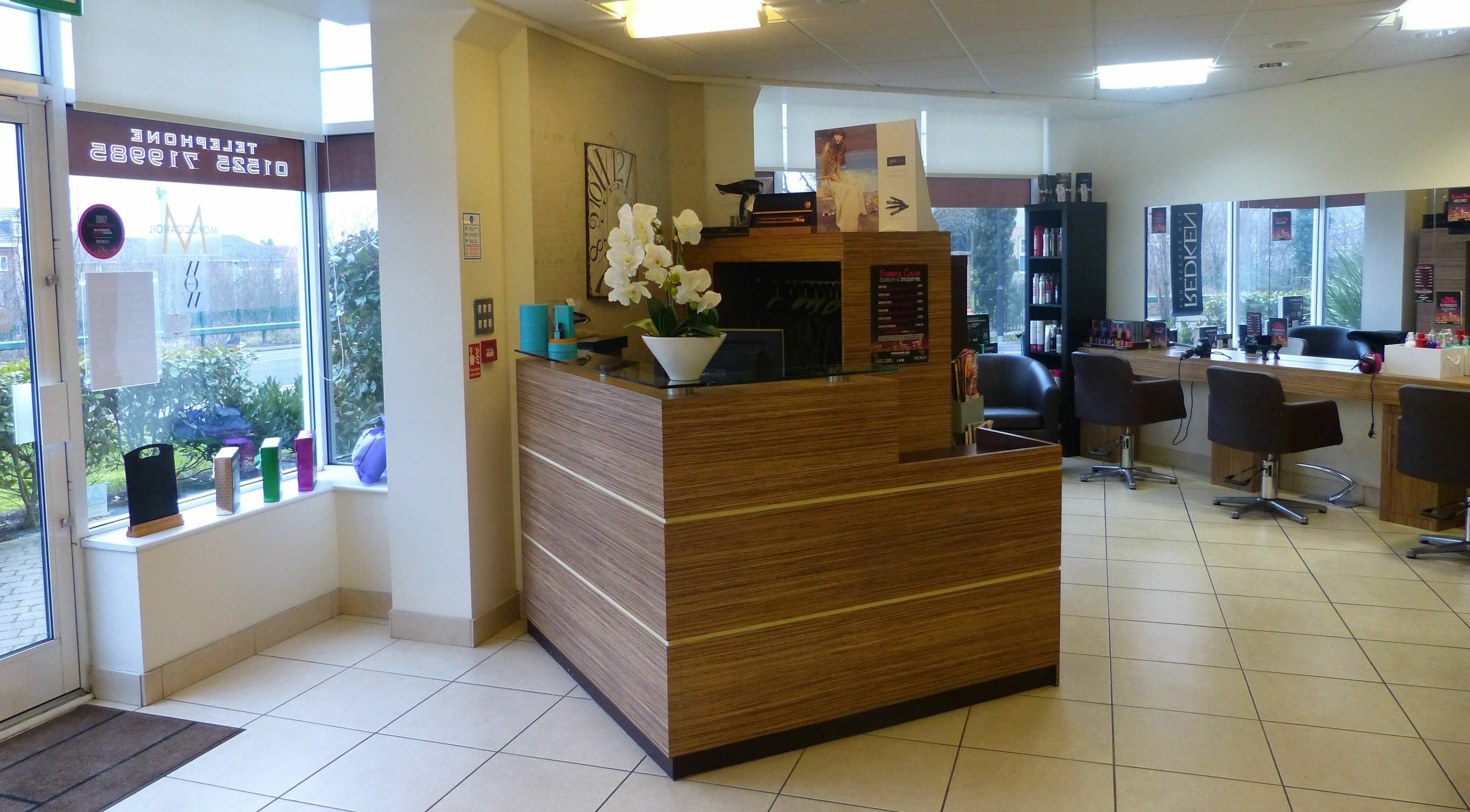 Reception area of Principles Hair Design Ltd in Flitwick, England, GB featuring modern decor and seating.