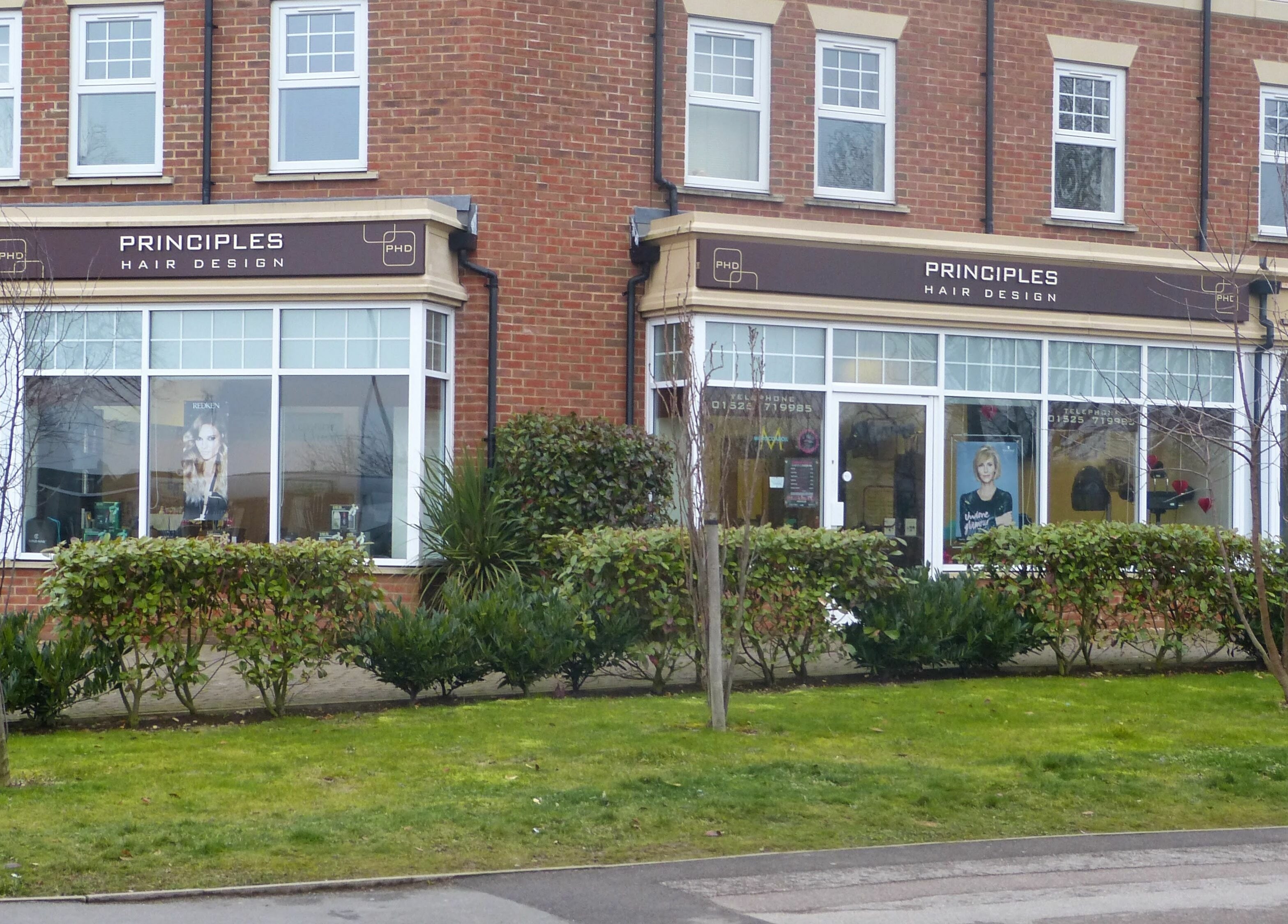 Front view of Principles Hair Design Ltd, a salon in Flitwick, England with elegant windows and signage.