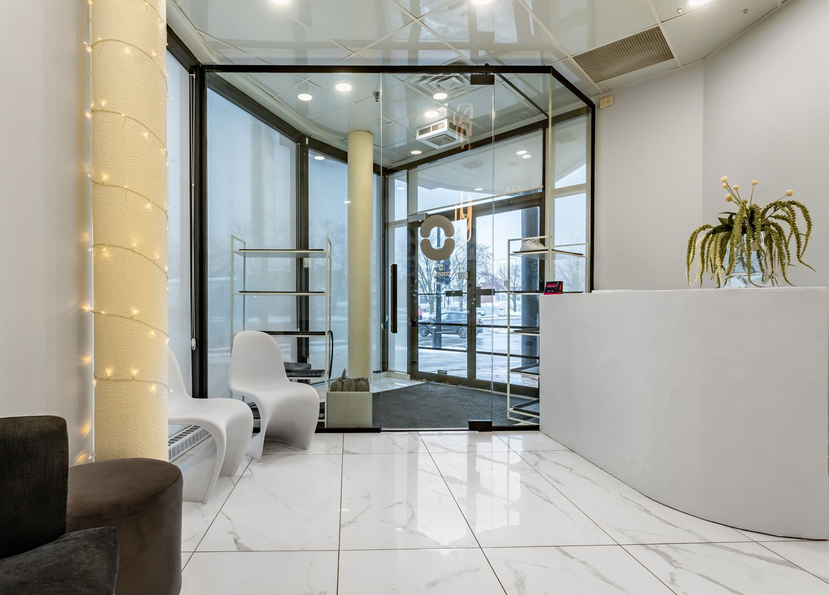 Bright, modern entrance of Cosmo in Montréal, Québec, CA with sleek white decor and cozy seating.