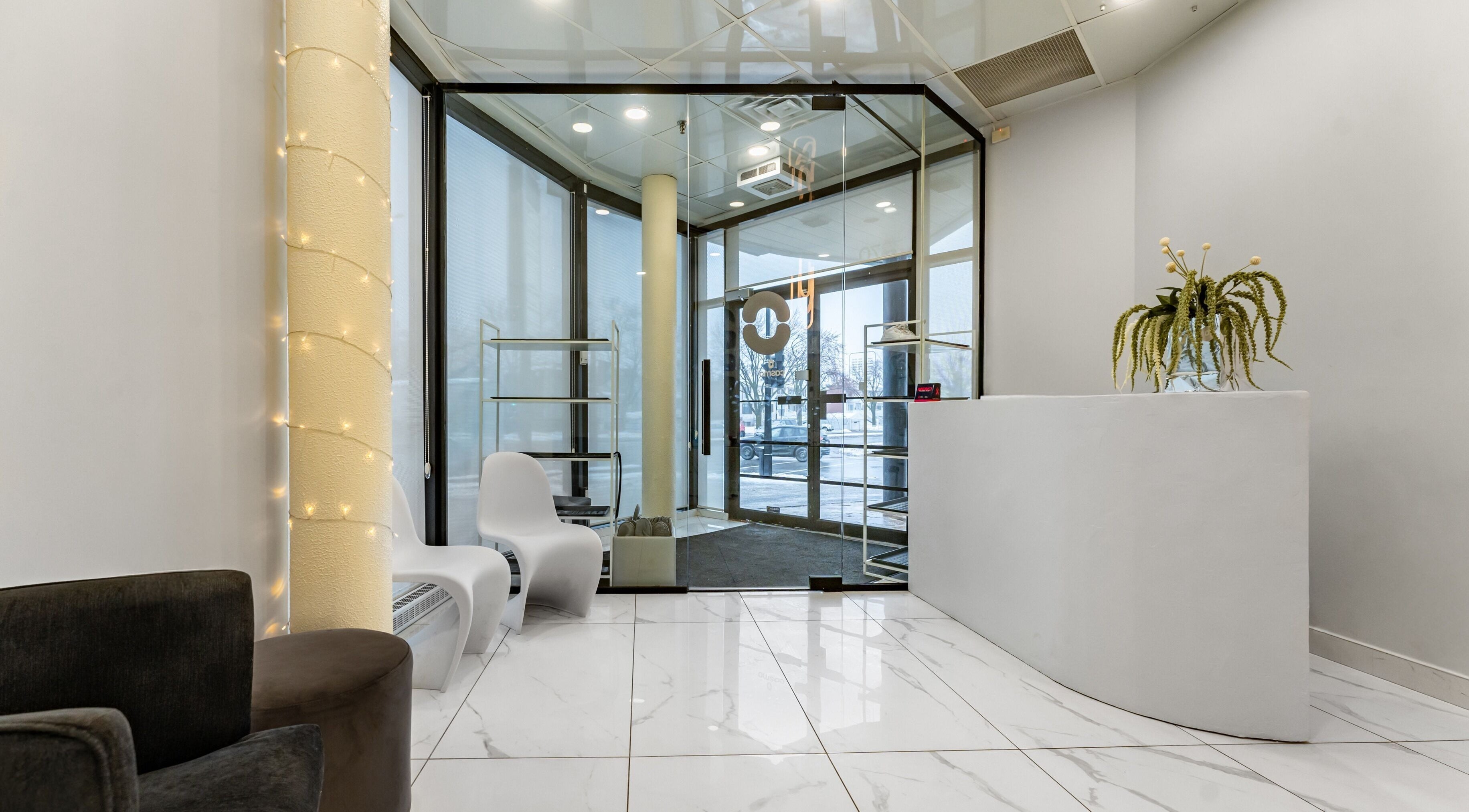 Bright, modern entrance of Cosmo in Montréal, Québec, CA with sleek white decor and cozy seating.