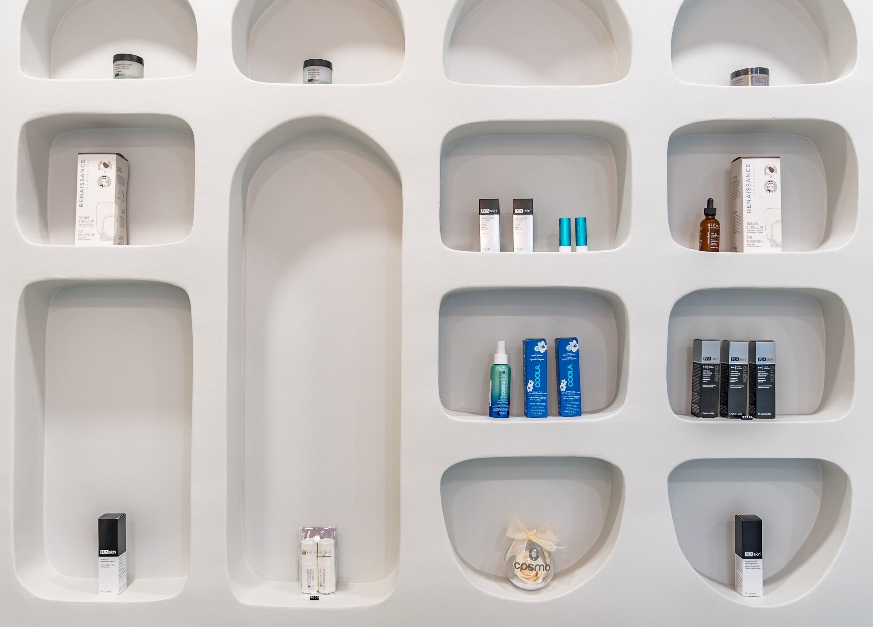 Stylish product display on white shelves at Cosmo, Montréal, Québec, CA, showcasing beauty essentials.