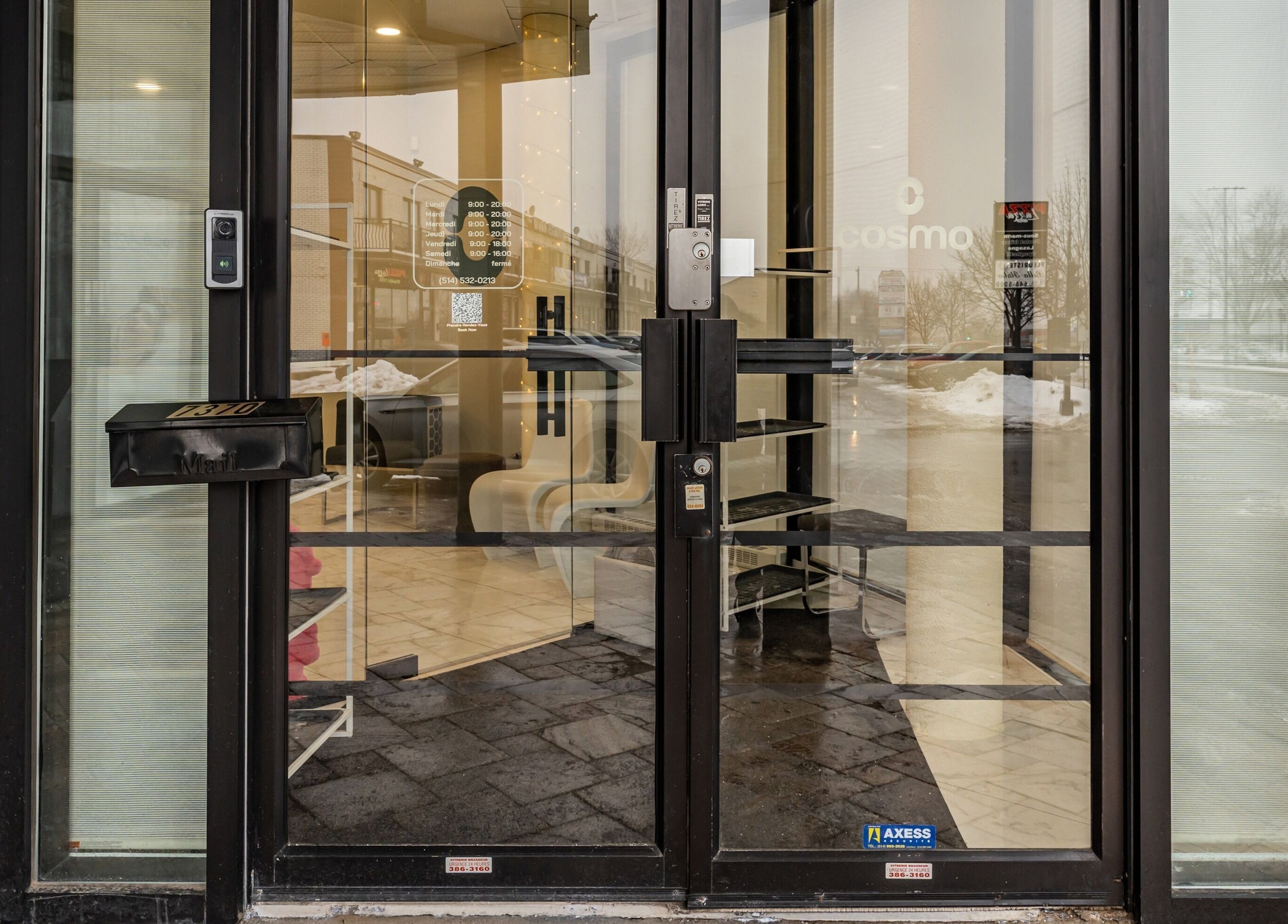 Entrance of Cosmo in Montréal, Québec, CA with glass doors and modern decor.