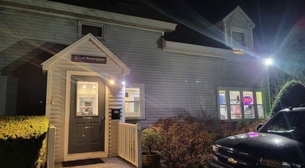 Gents Barber Shop entrance at night, warmly lit in Hampton, New Hampshire, US.