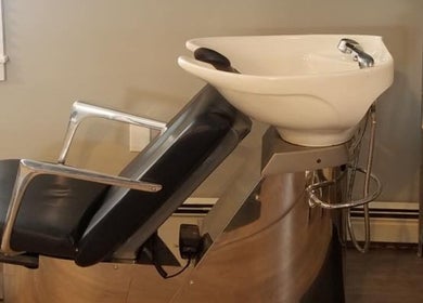 Modern barber chair and sink in Gents Barber Shop, Hampton, New Hampshire, US.