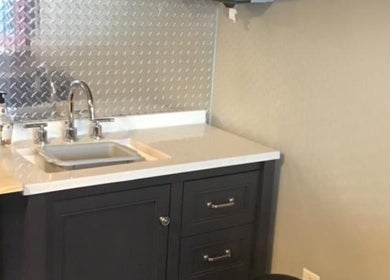 Modern sink area at Gents Barber Shop in Hampton, New Hampshire, US featuring contemporary metal backsplash.