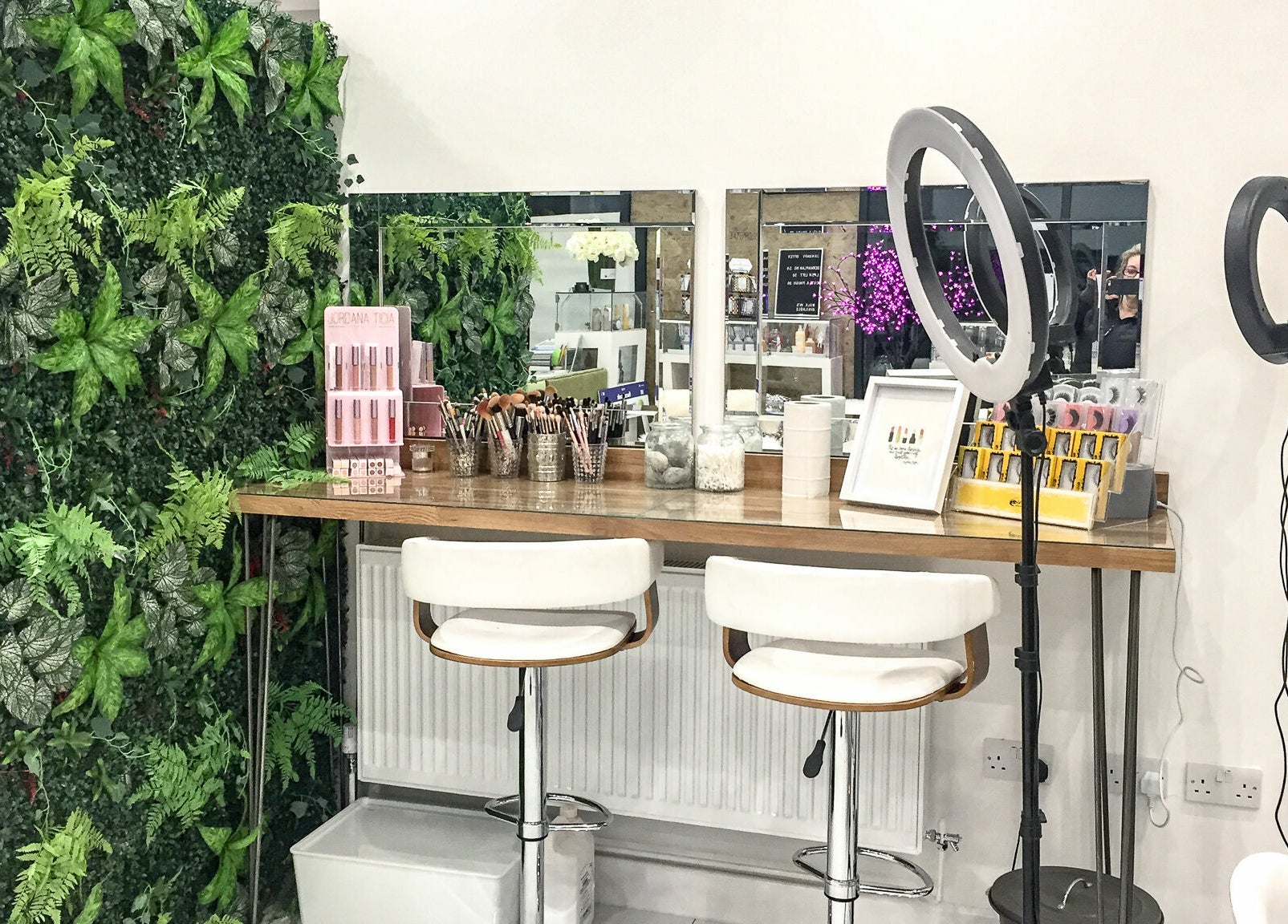Makeup station at Glam and Go, Bamber Bridge, England, GB, with mirrors, tools, and lush green decor.