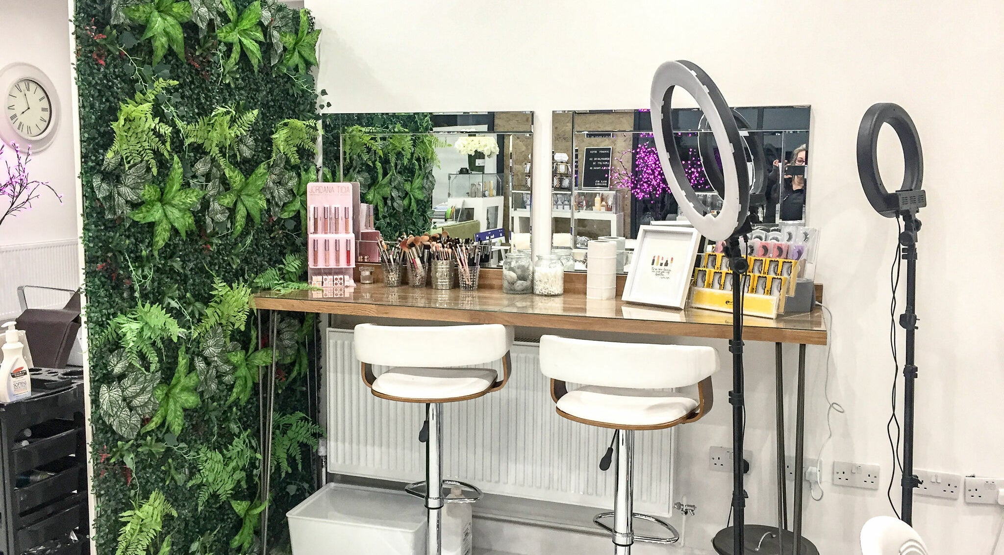 Makeup station at Glam and Go, Bamber Bridge, England, GB, with mirrors, tools, and lush green decor.