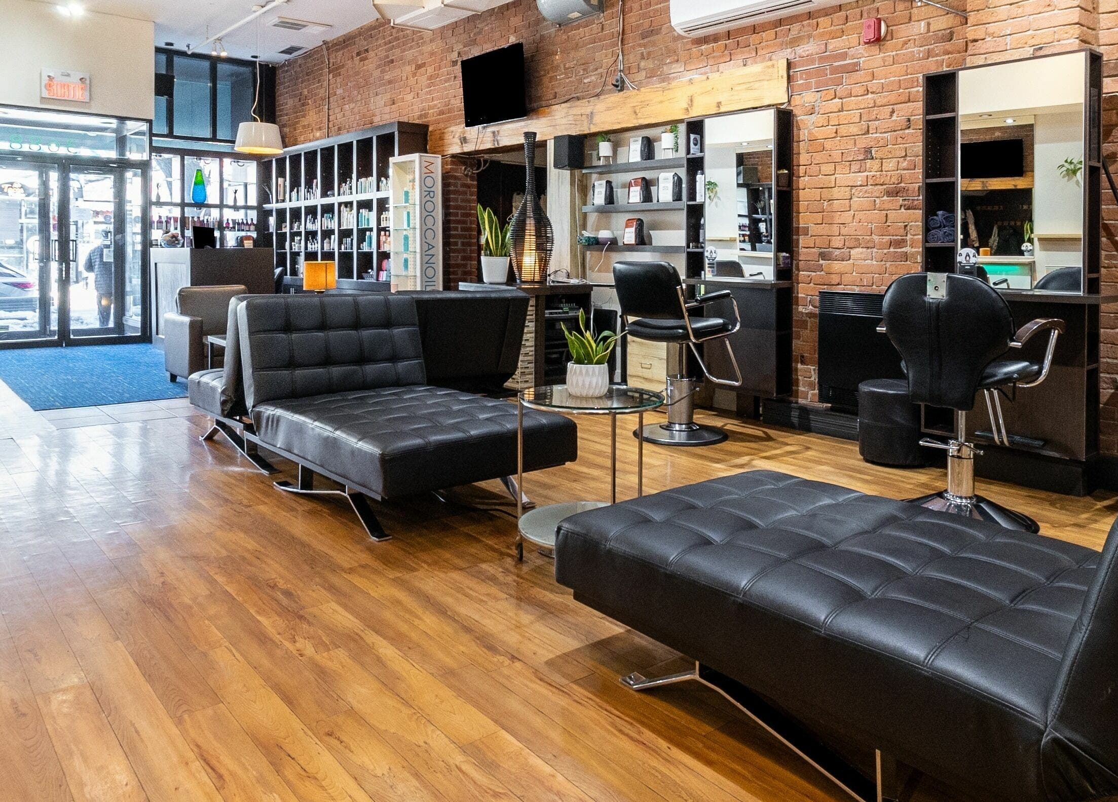 Salon moderne de Funky Toque à Montréal, Québec, CA, avec sièges élégants et murs en briques.