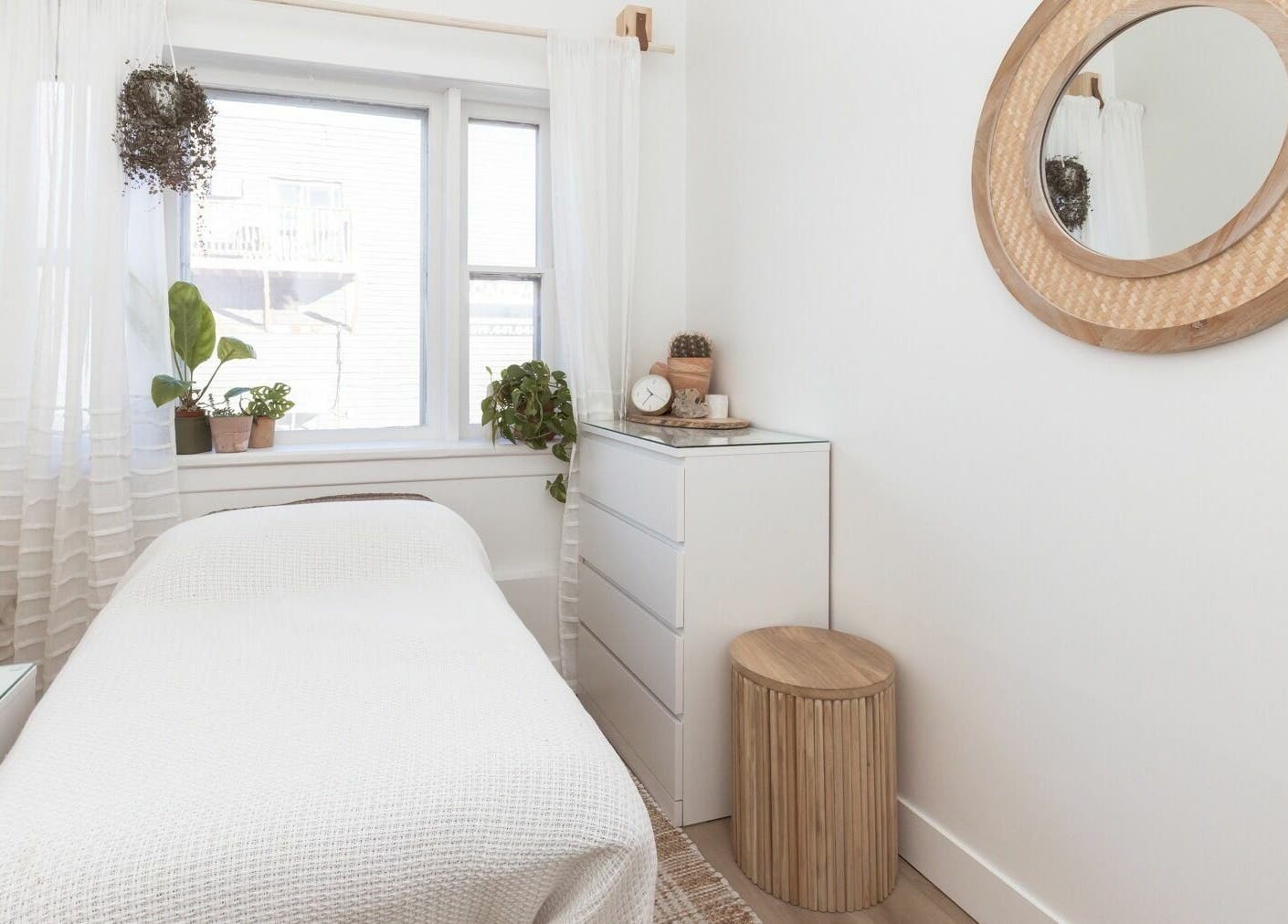 Relaxing treatment room at Lifted Lash Lounge and Wellness Spa, Clinton, Ontario, CA with cozy white decor.