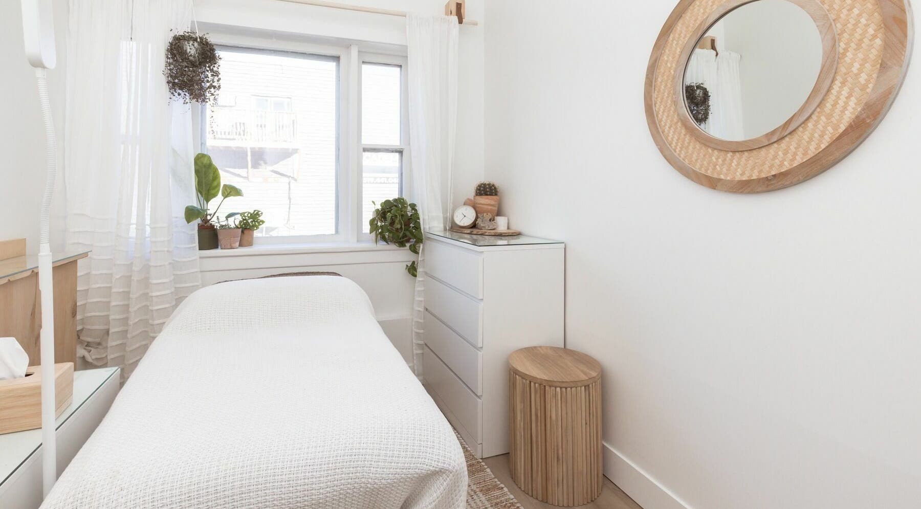 Relaxing treatment room at Lifted Lash Lounge and Wellness Spa, Clinton, Ontario, CA with cozy white decor.